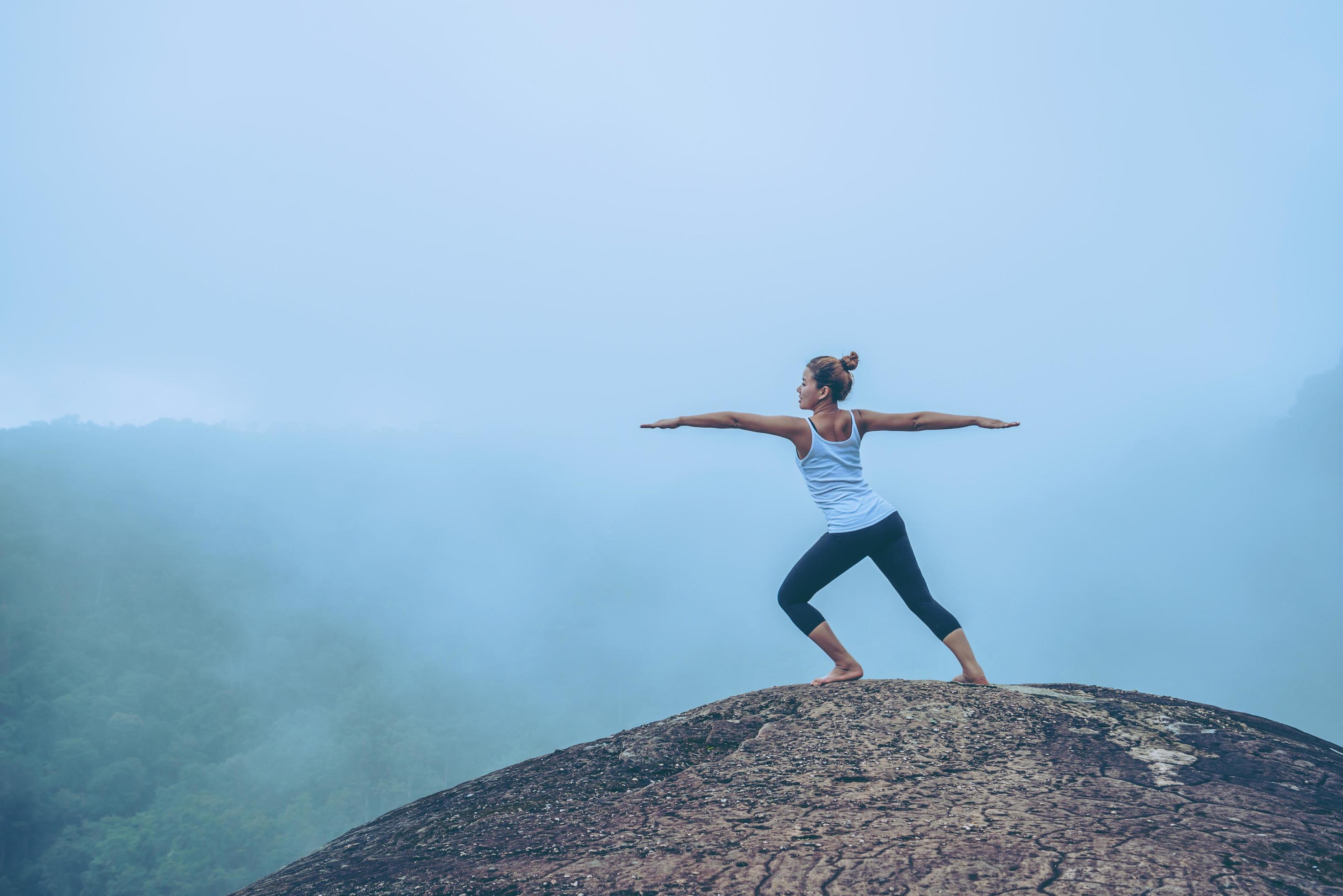 Asian women relax in the holiday. Travel relax. Play if yoga. On the Moutain rock cliff. Nature of mountain forests in Thailand Stock Free