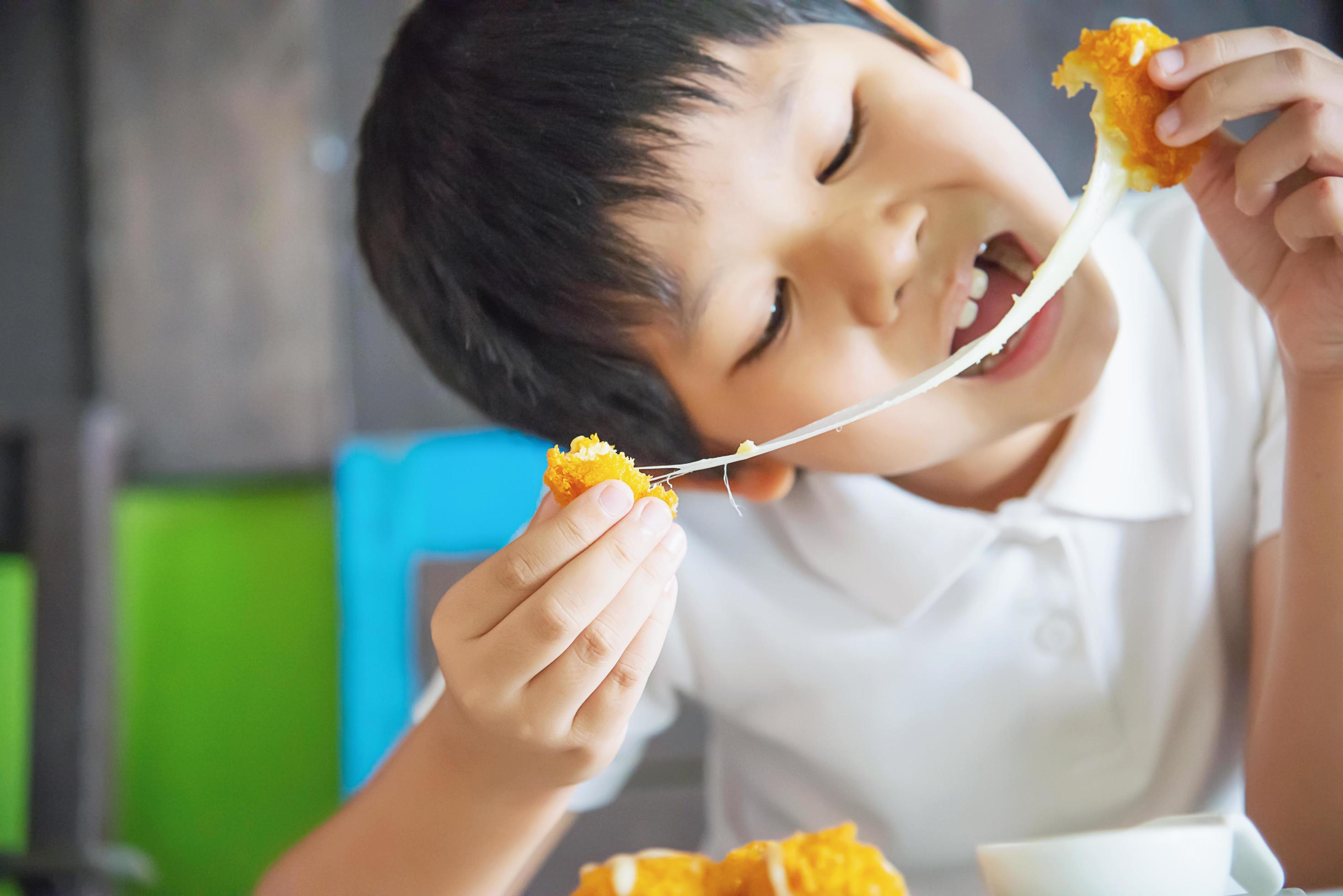 Boy ready to eat sticky stretch fried cheese ball – people and delicious cheese food concept Stock Free