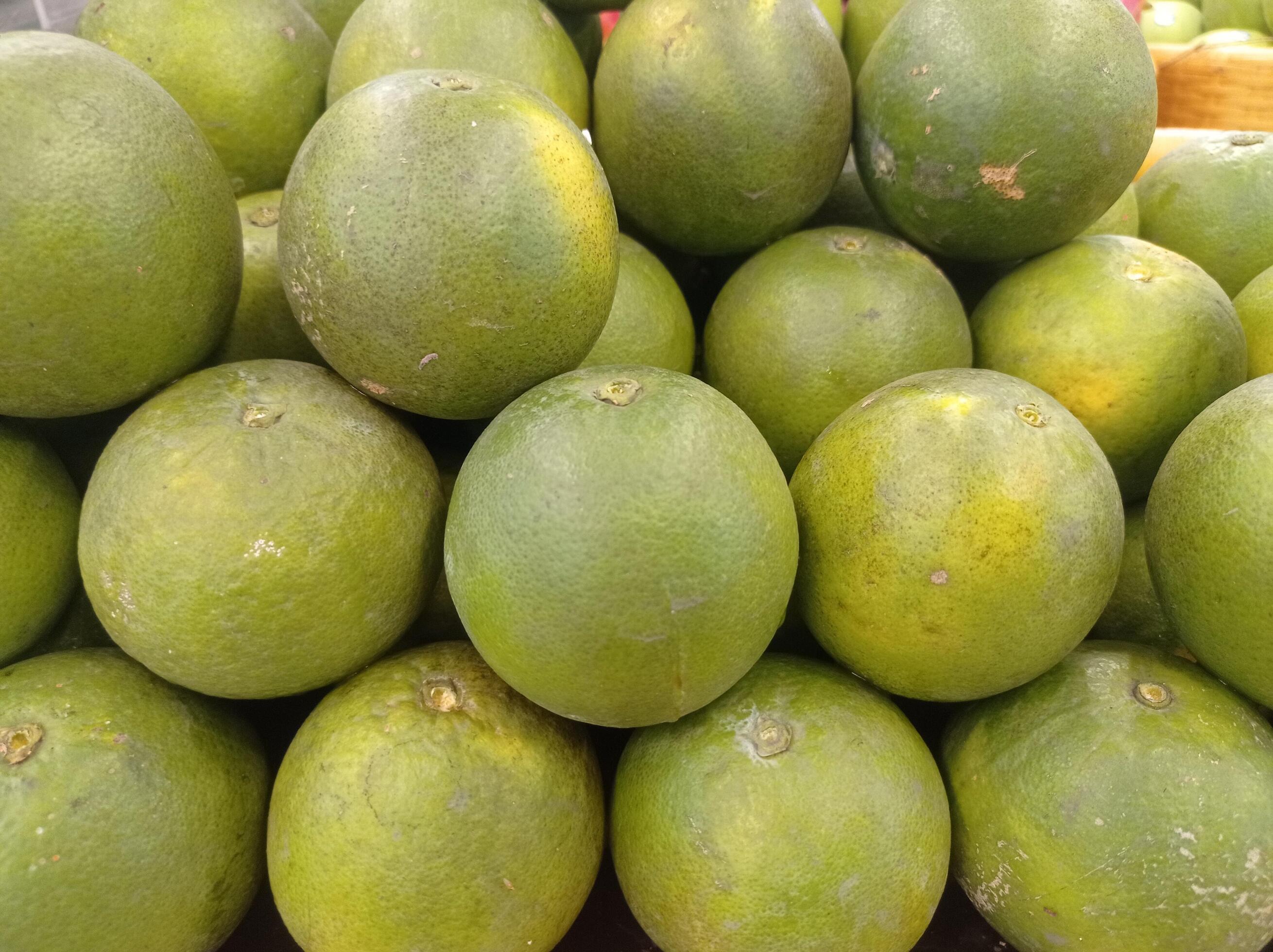 Fresh green oranges in mini market basket Stock Free