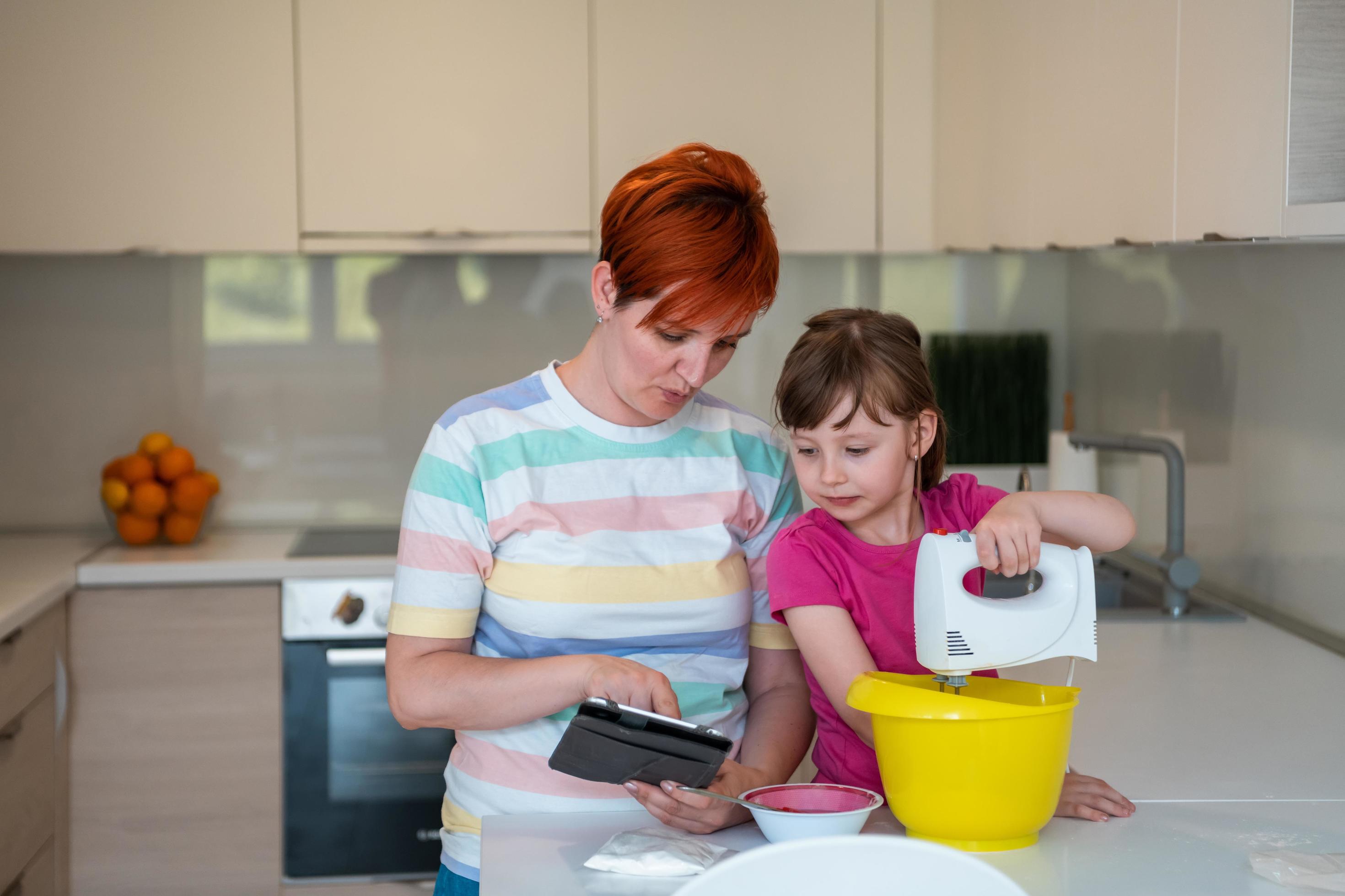 little girl and mom making tastz cake in kithen family having fun at home Stock Free