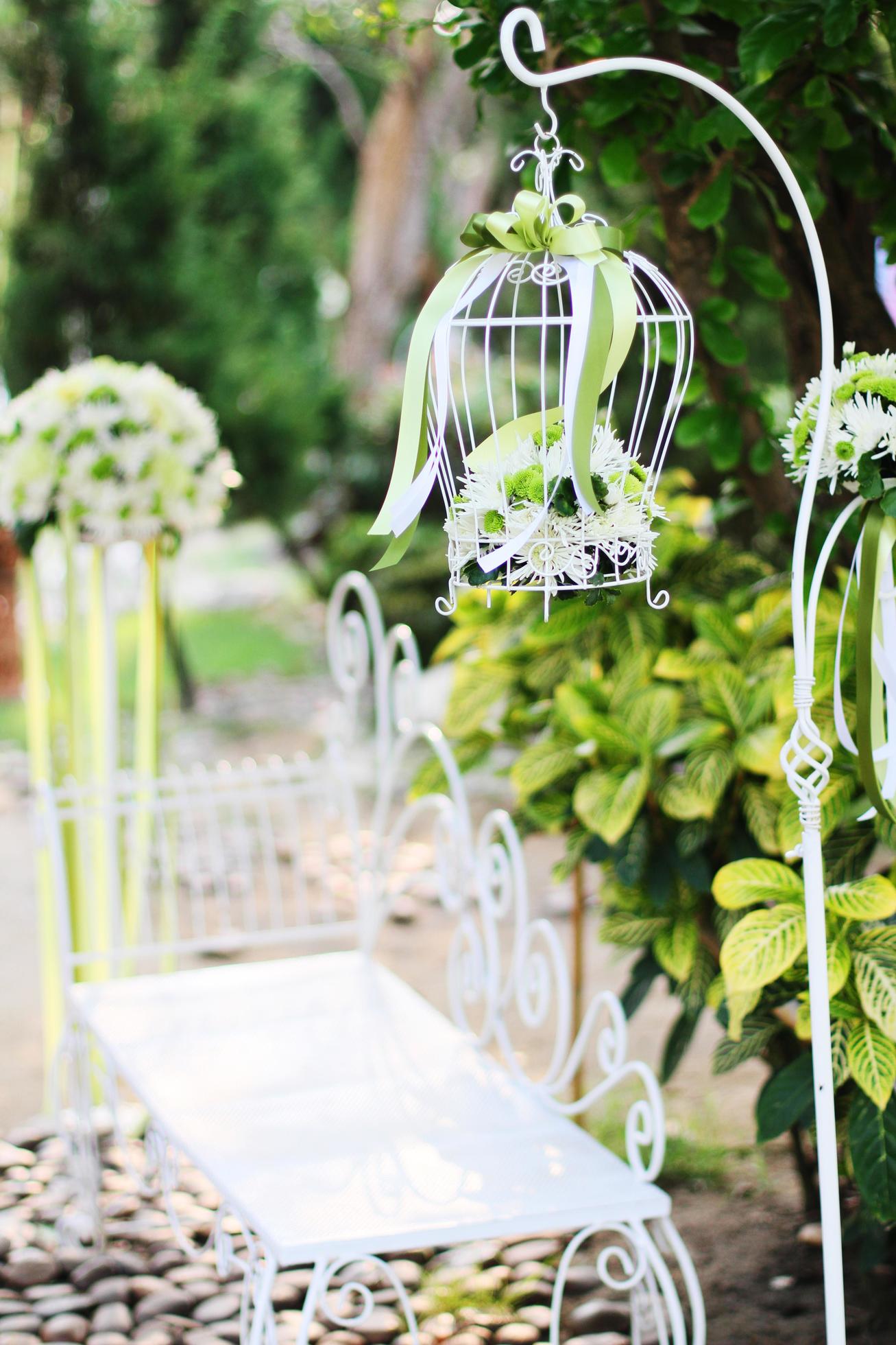 White birdcage, chair decoration with roses and white flowers hanging decoration in garden for wedding ceremony Stock Free