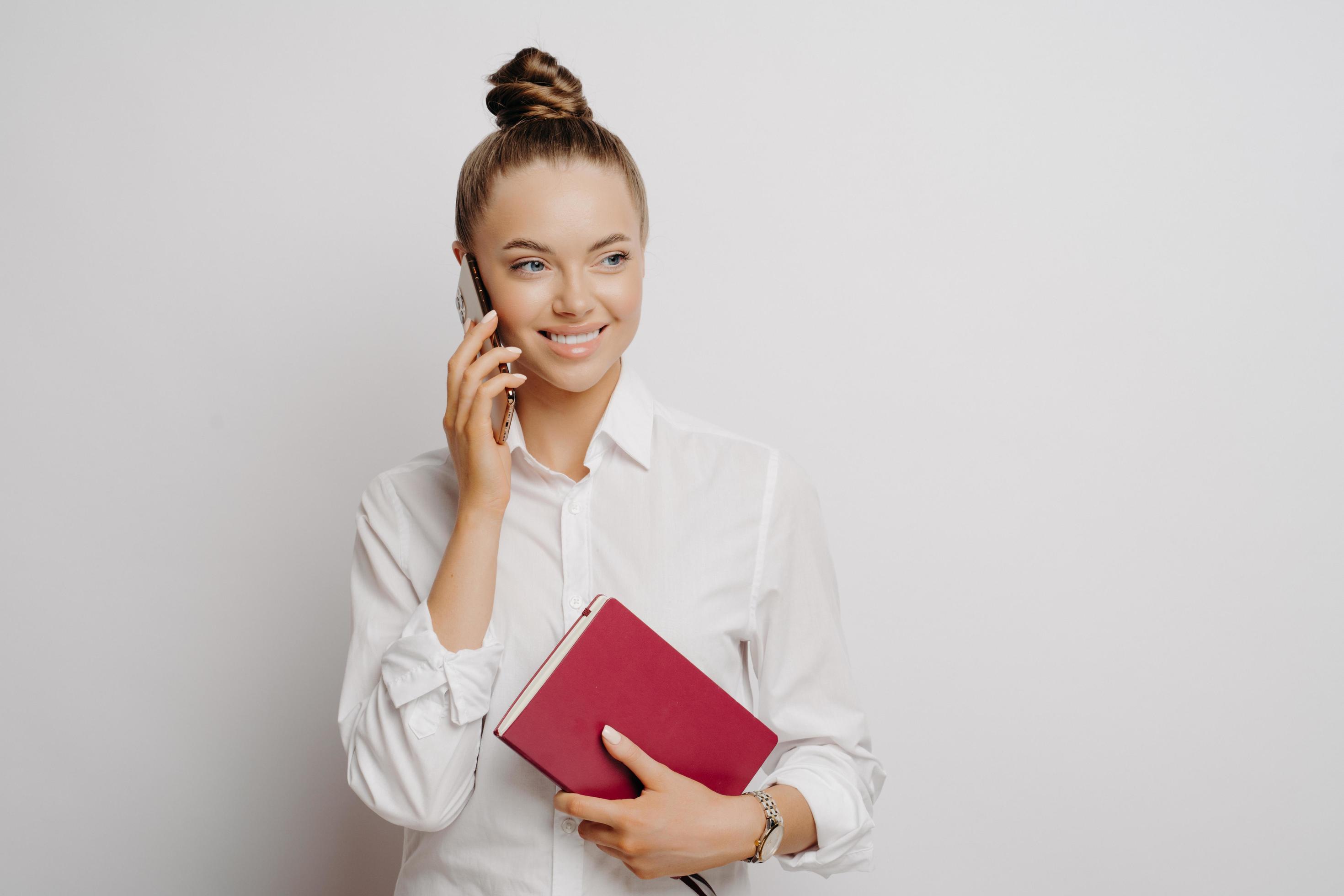 Happy business woman in white shirt with phone and notebook Stock Free