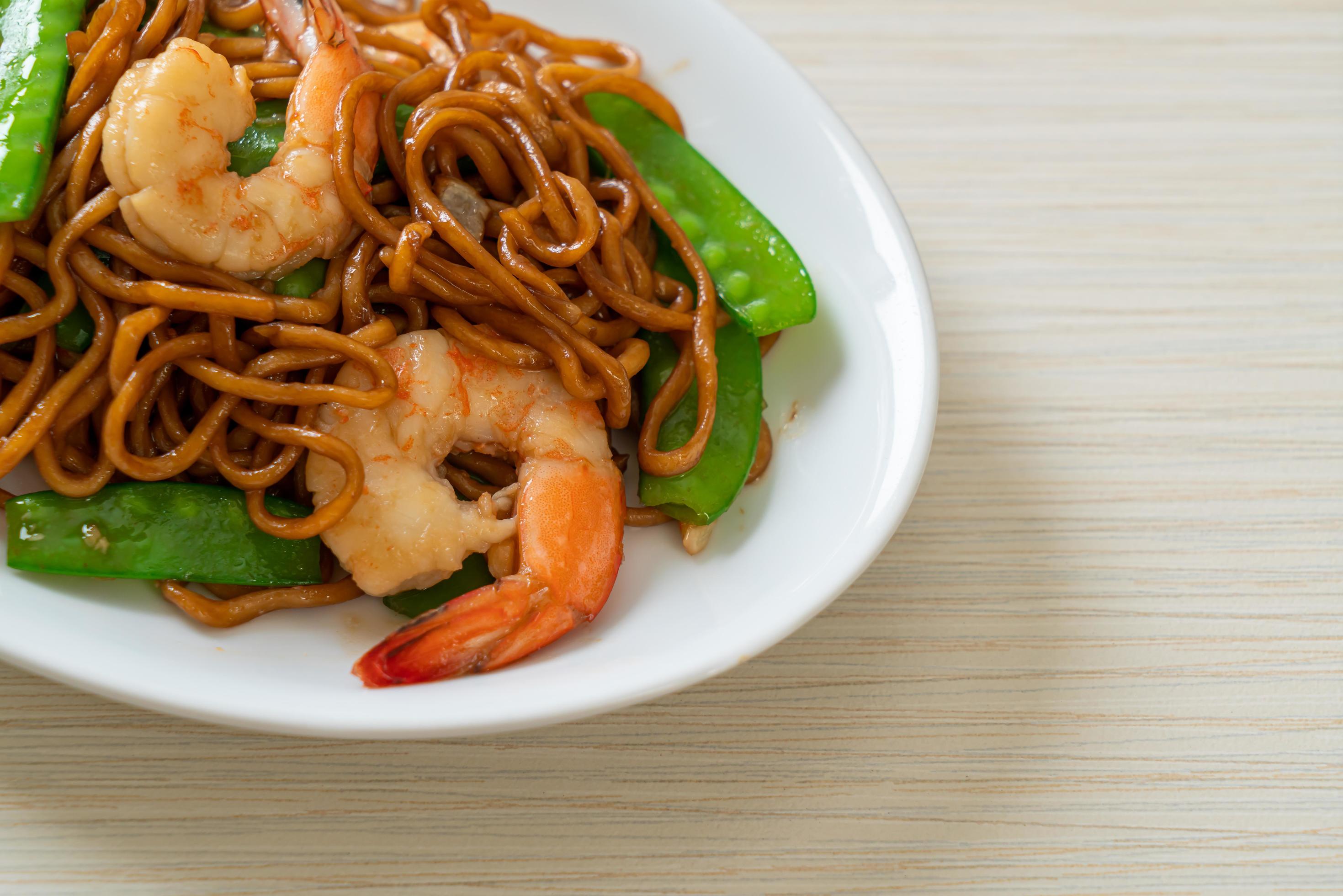 Stir-fried yakisoba noodles with green peas and shrimps – Asian food style Stock Free