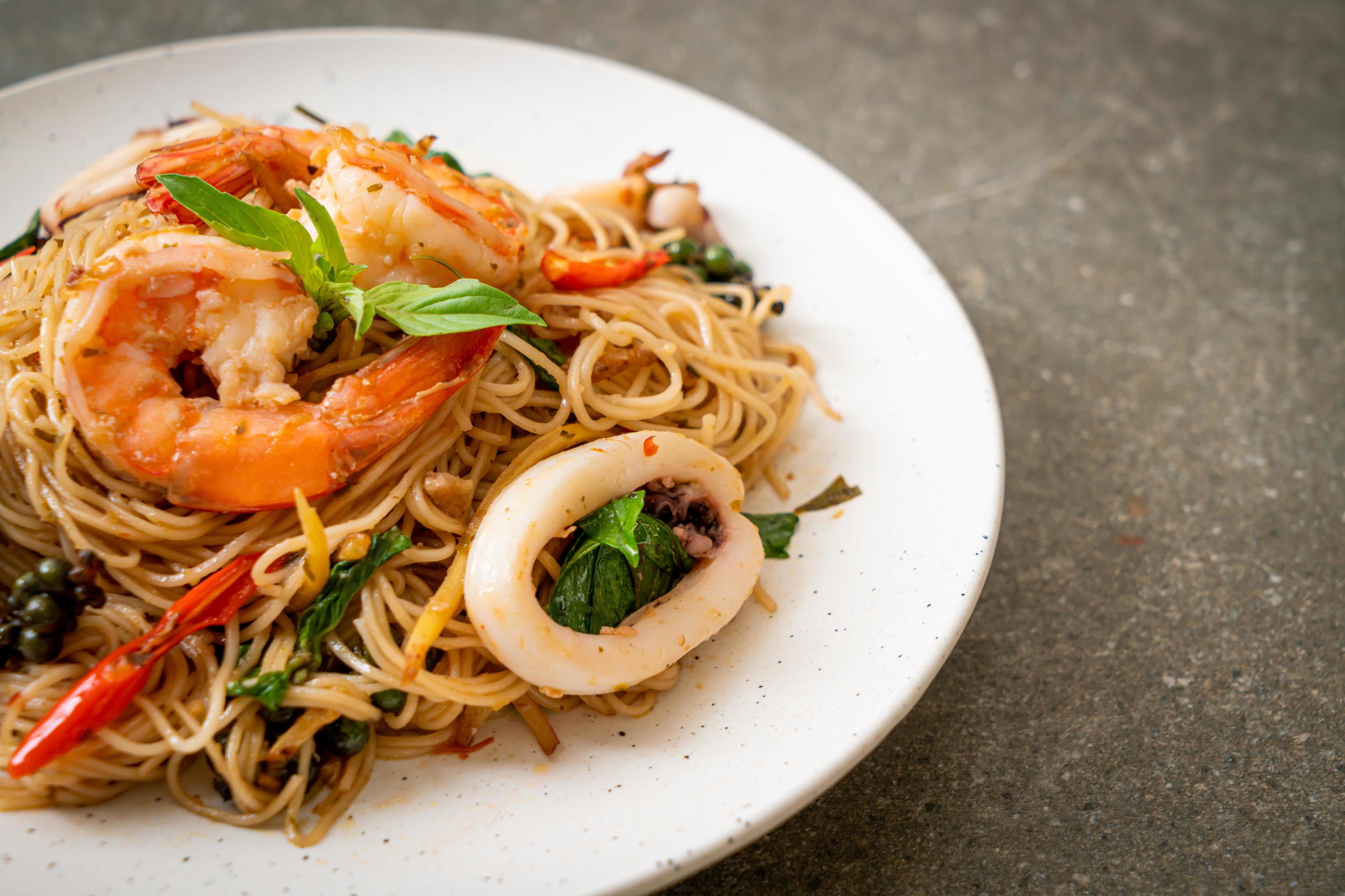 Stir-fried Chinese noodles with basil, chili, shrimp, and squid – Asian food style Stock Free