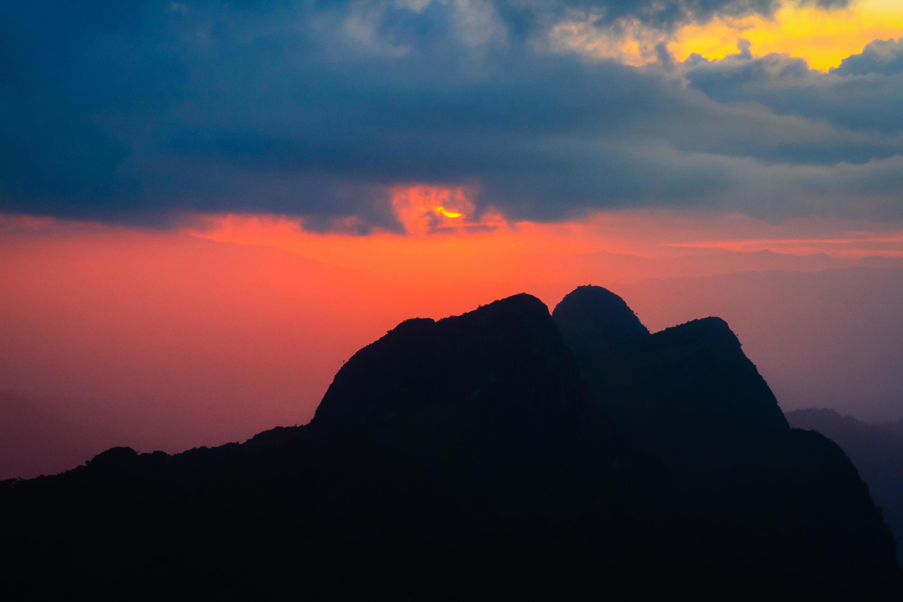 Sunset in sky and cloud, beautiful colorful twilight time with silhouette of mountain. Stock Free