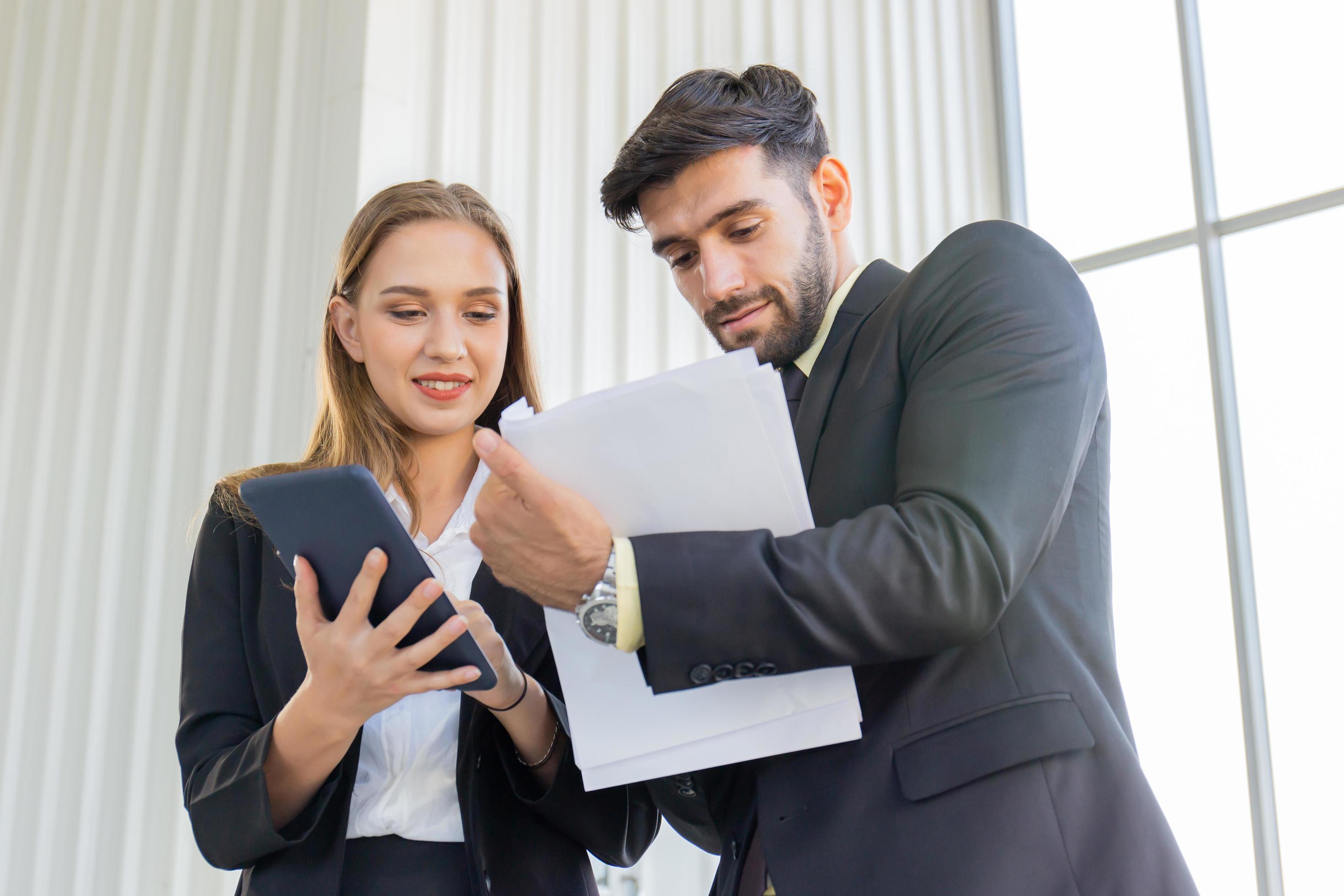 Two business men and women standing meeting in the office Stock Free