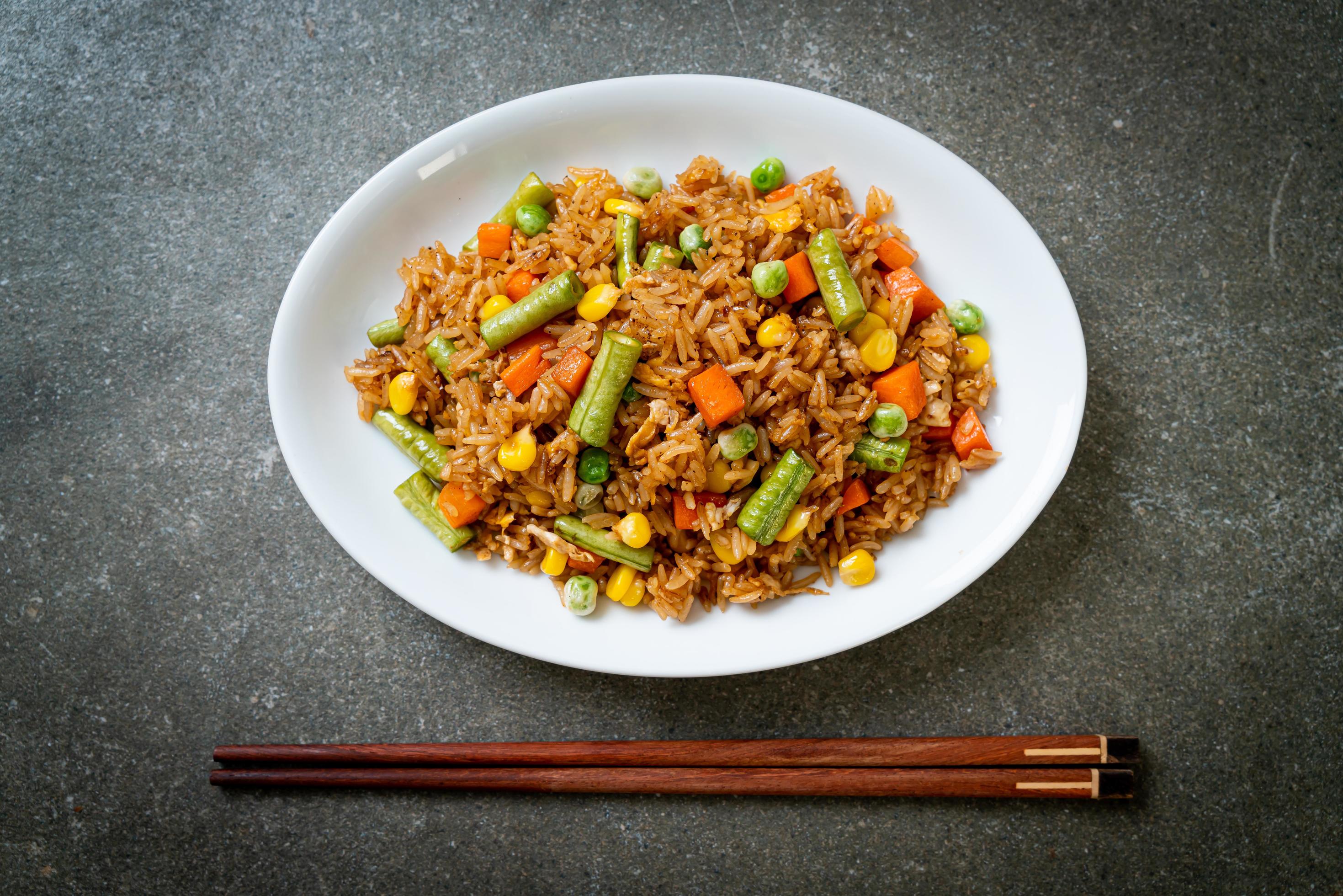 Fried rice with green peas, carrots, and corn – vegetarian and healthy food style Stock Free