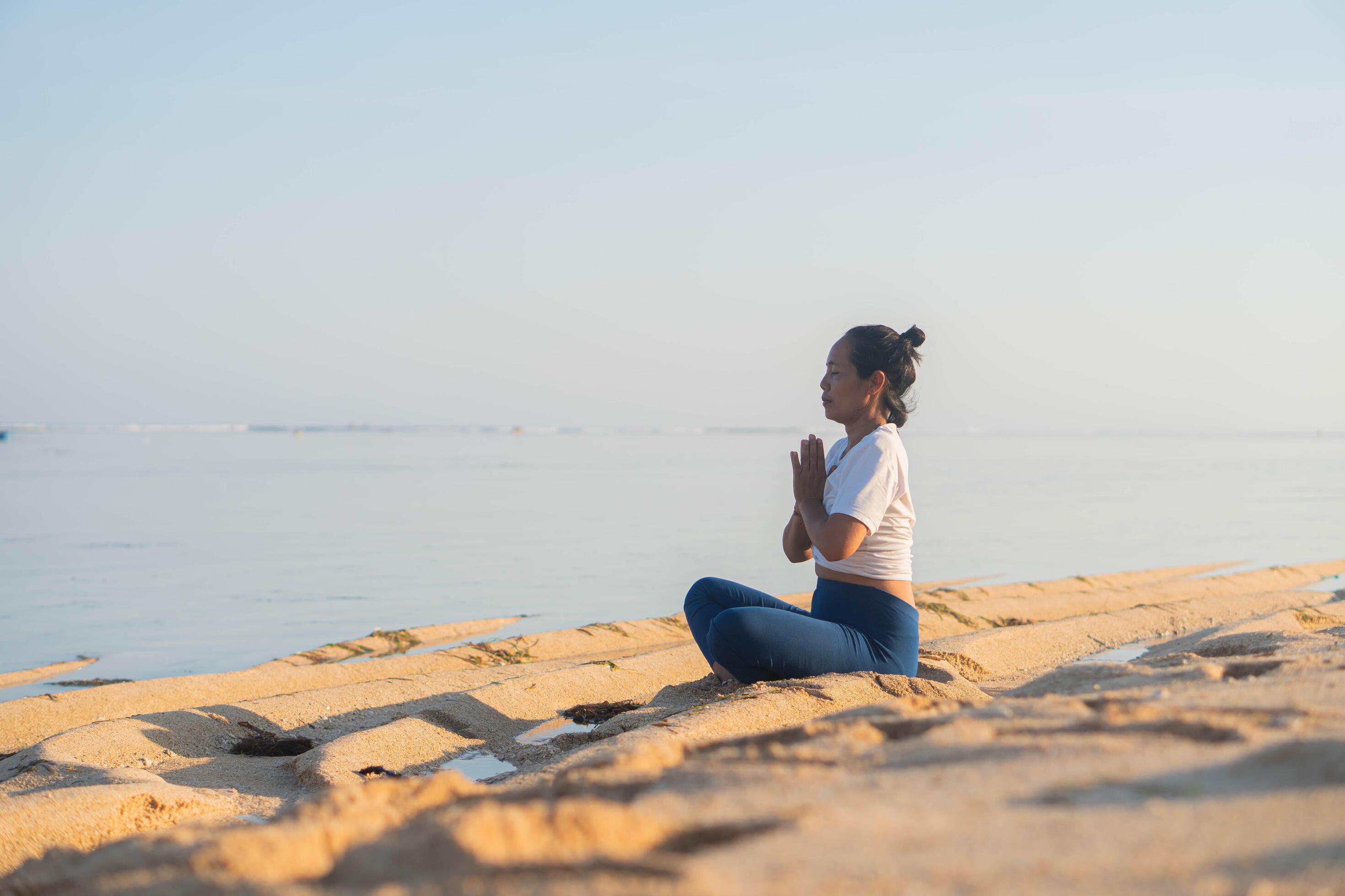 healthy woman with beautiful body doing yoga at sunrise on the beach, yoga poses Stock Free