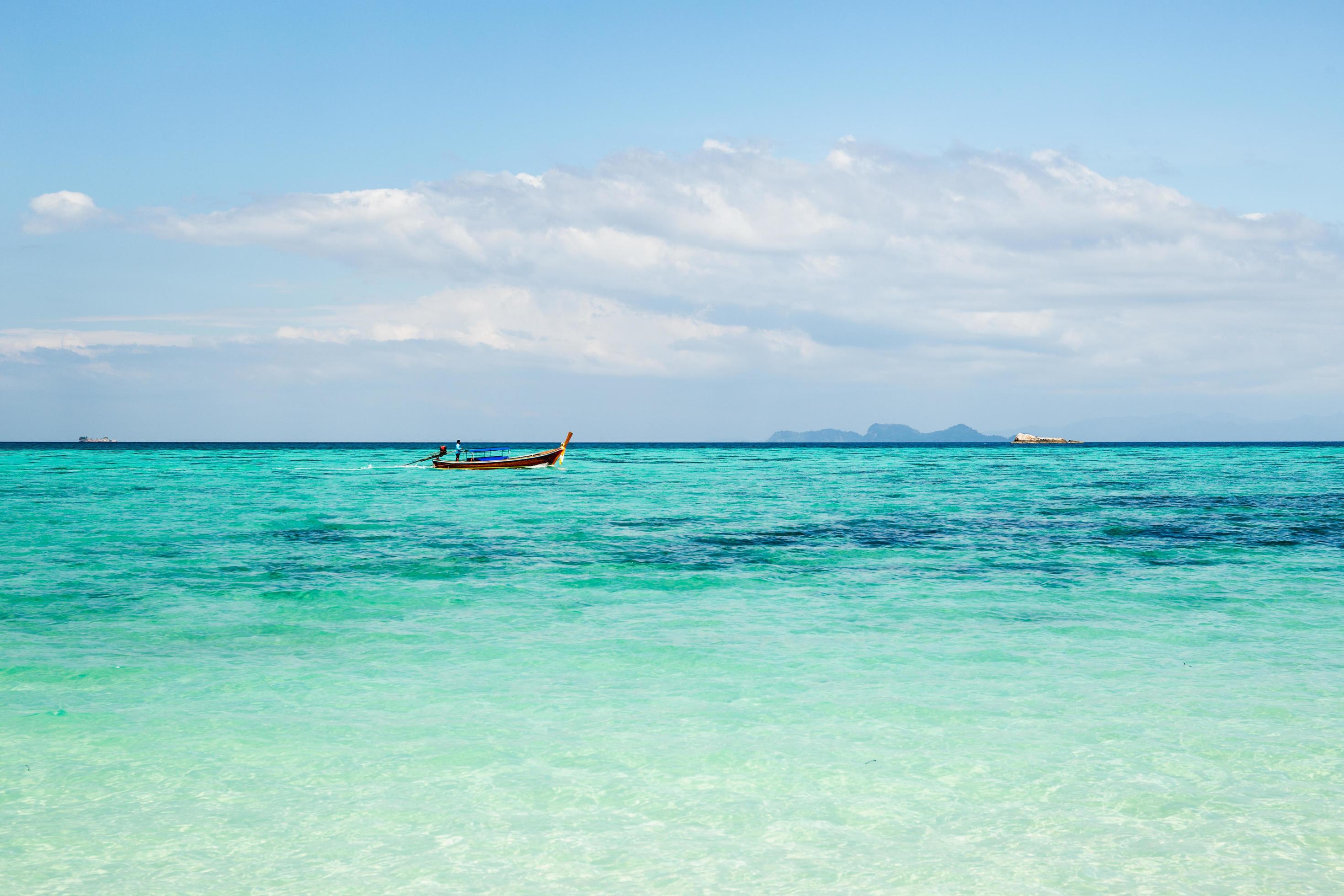 Turqoise sea with long tail boat in tropical island. Stock Free