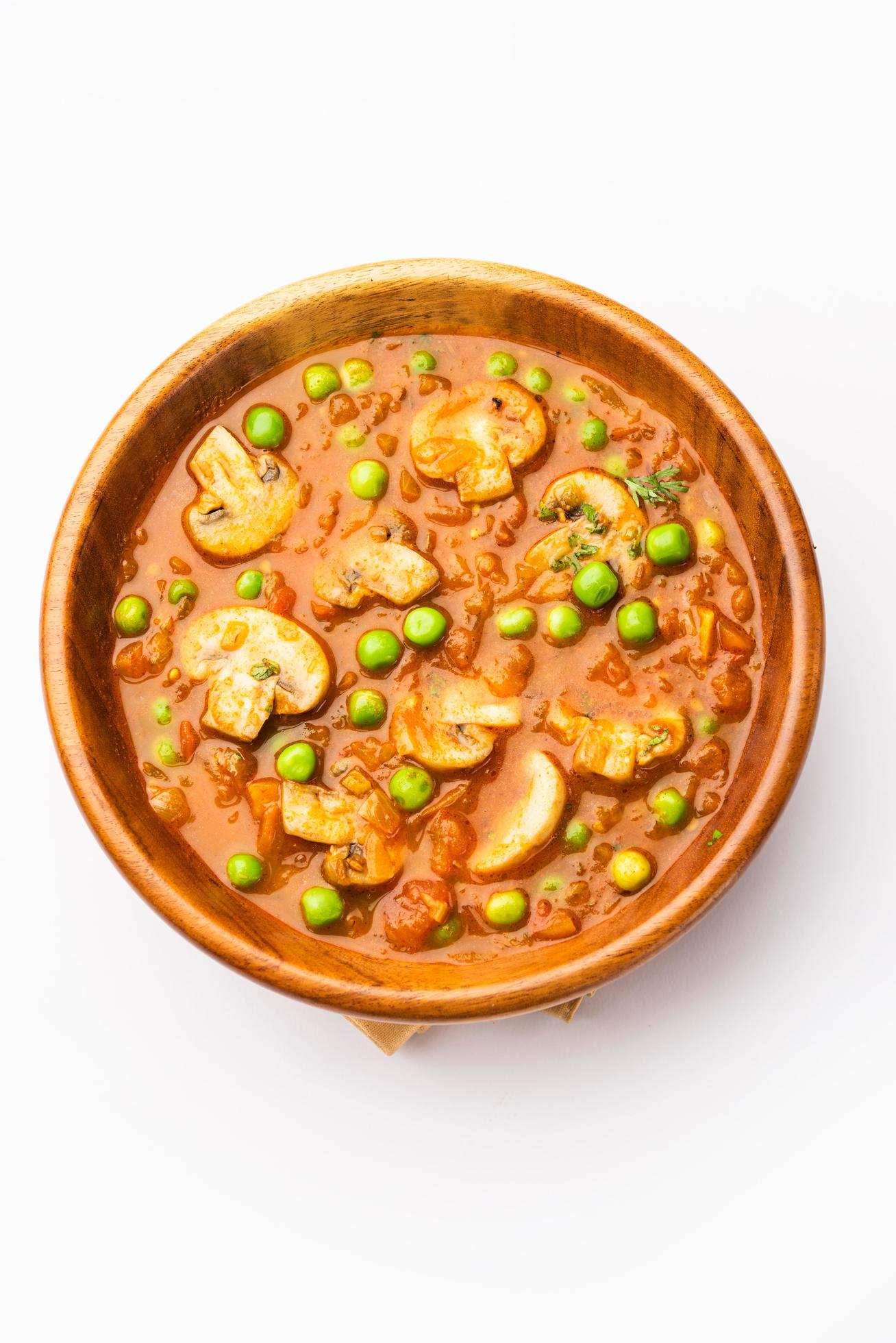 Mushroom and Pea Curry with Roasted Garlic, Indian food served in a bowl Stock Free