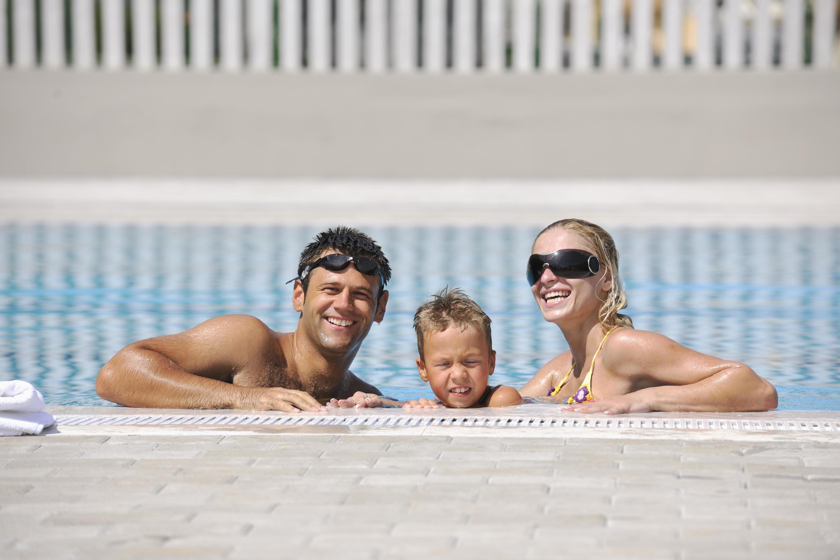 happy young family have fun on swimming pool Stock Free