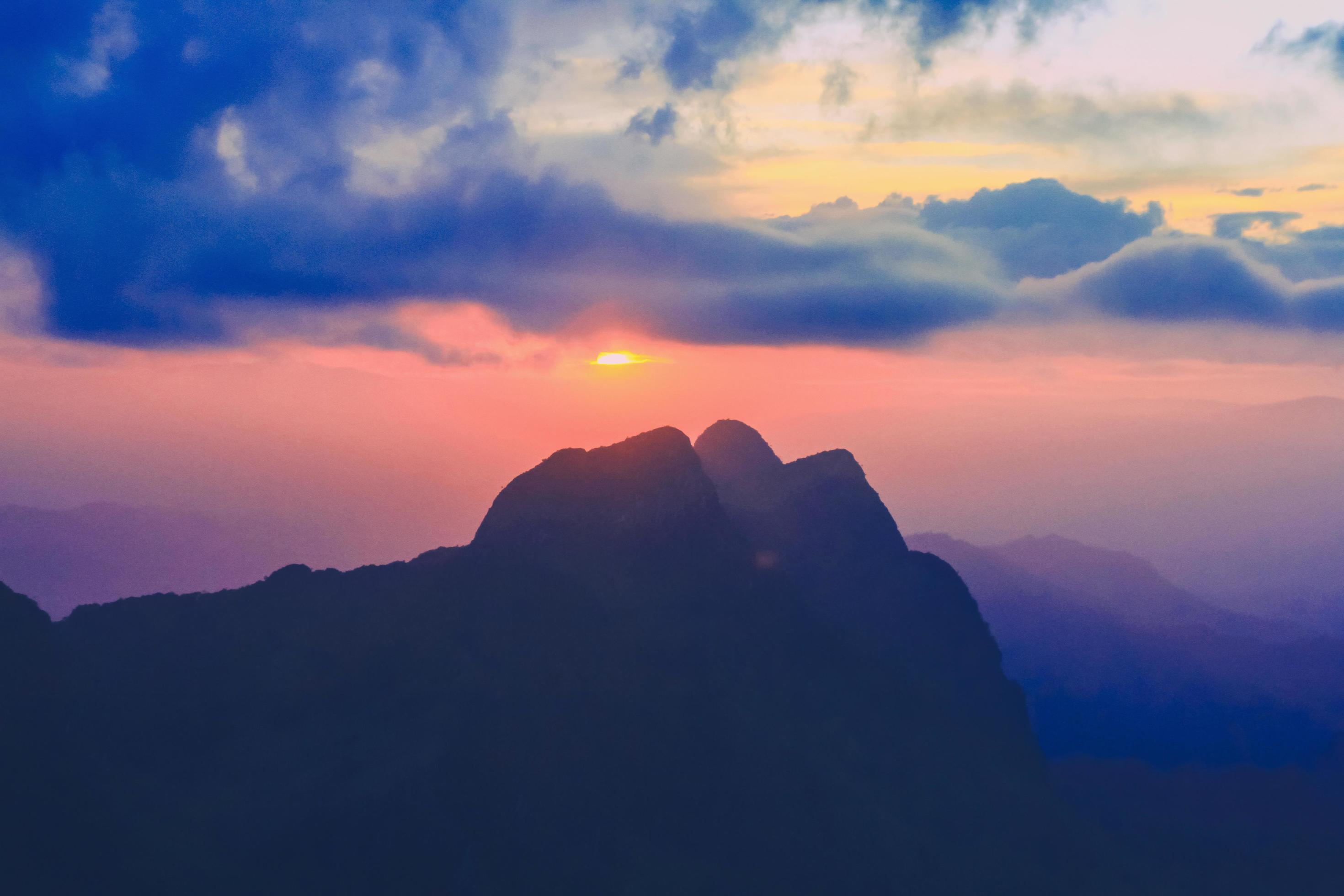 Sunset in sky and cloud, beautiful colorful twilight time with silhouette of mountain. Stock Free