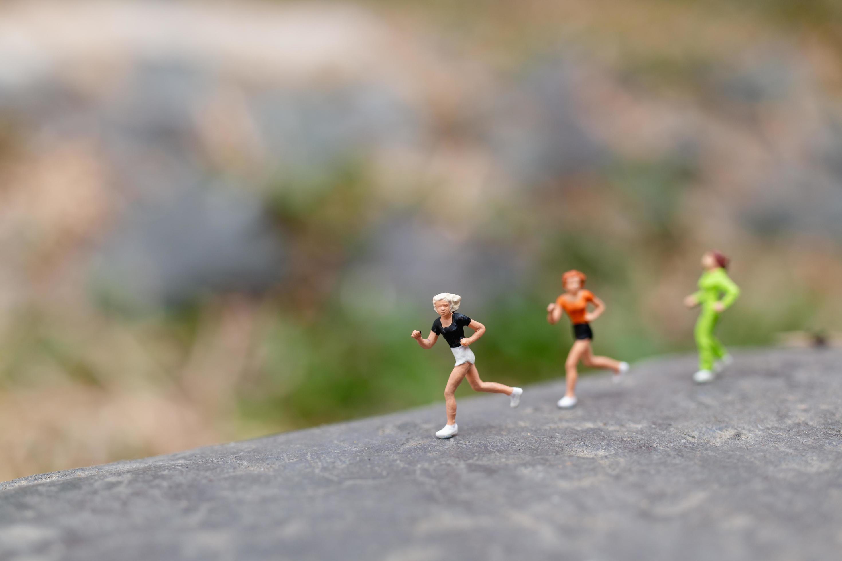 Miniature people running on a rock, health and lifestyle concept Stock Free