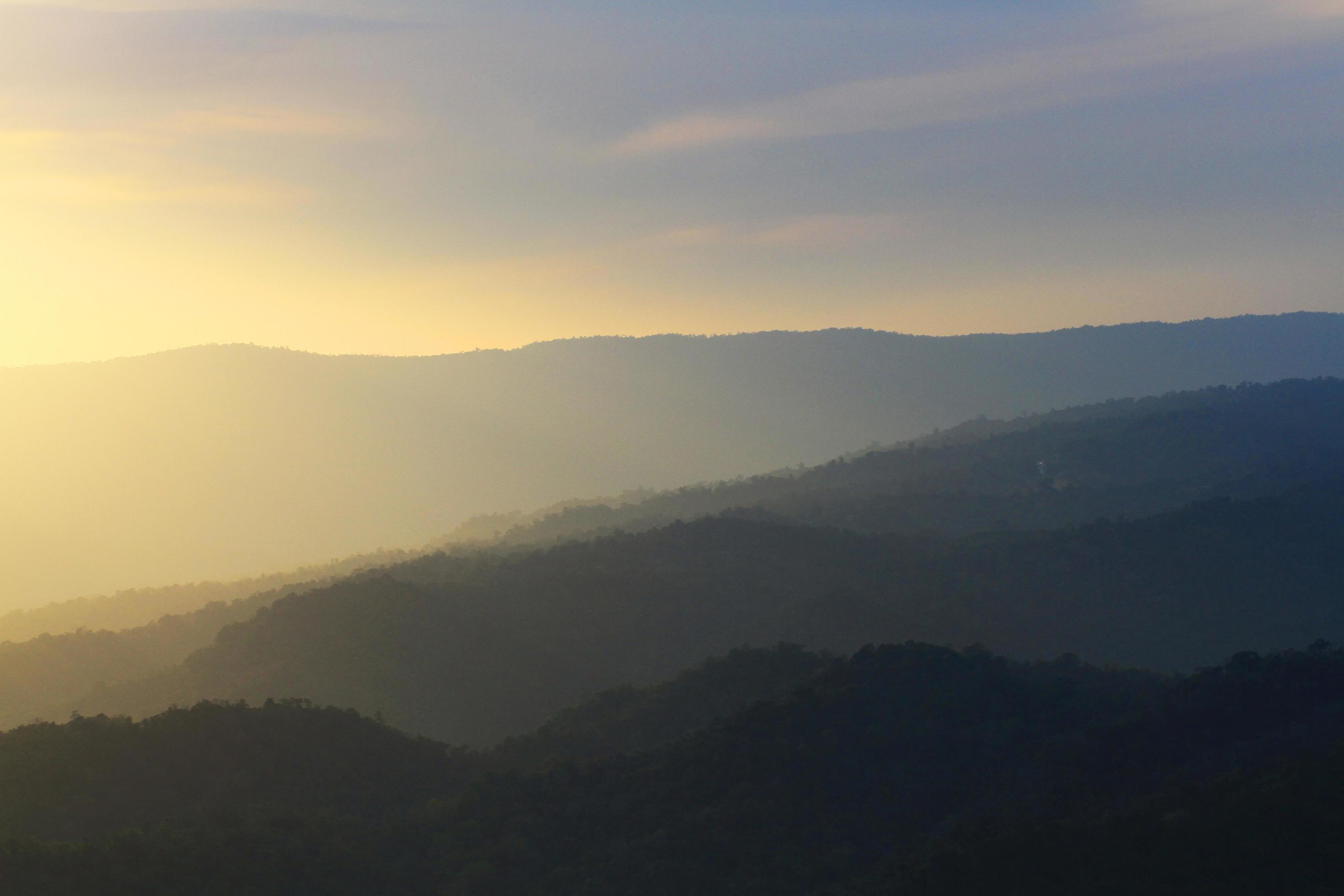 Beautiful landscape layers of mountain and Misty on hill valley in golden twilight of sunset at Thailand Stock Free