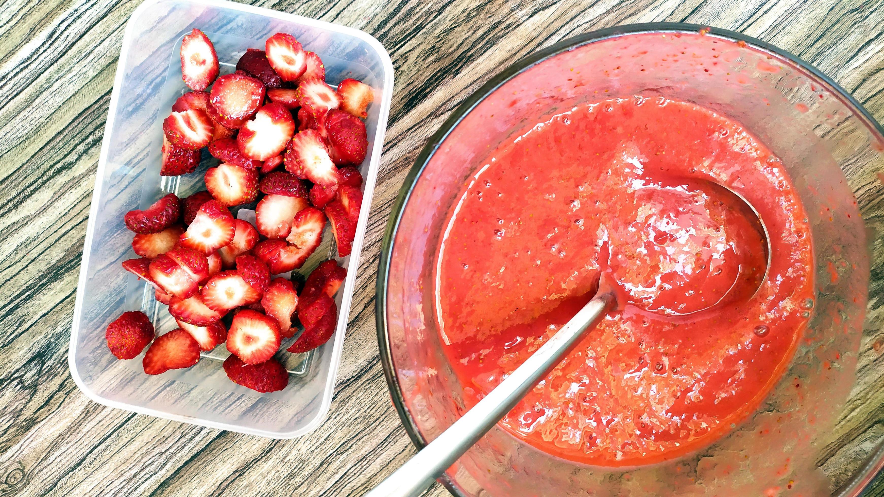 Strawberry puree and berries are placed in food containers Stock Free