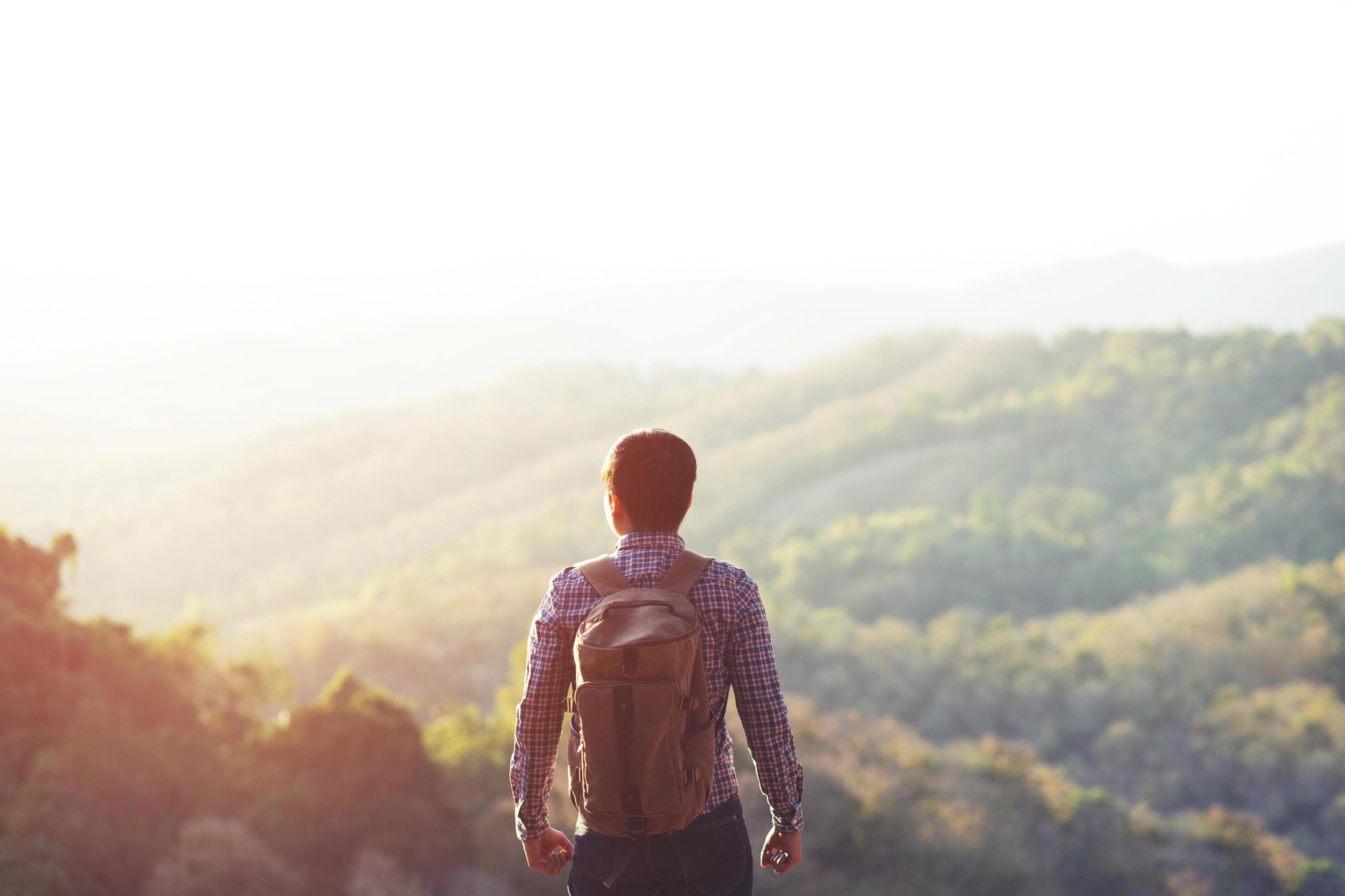 Man hiking at sunset mountains with heavy backpack Travel Lifestyle wanderlust adventure concept summer Stock Free