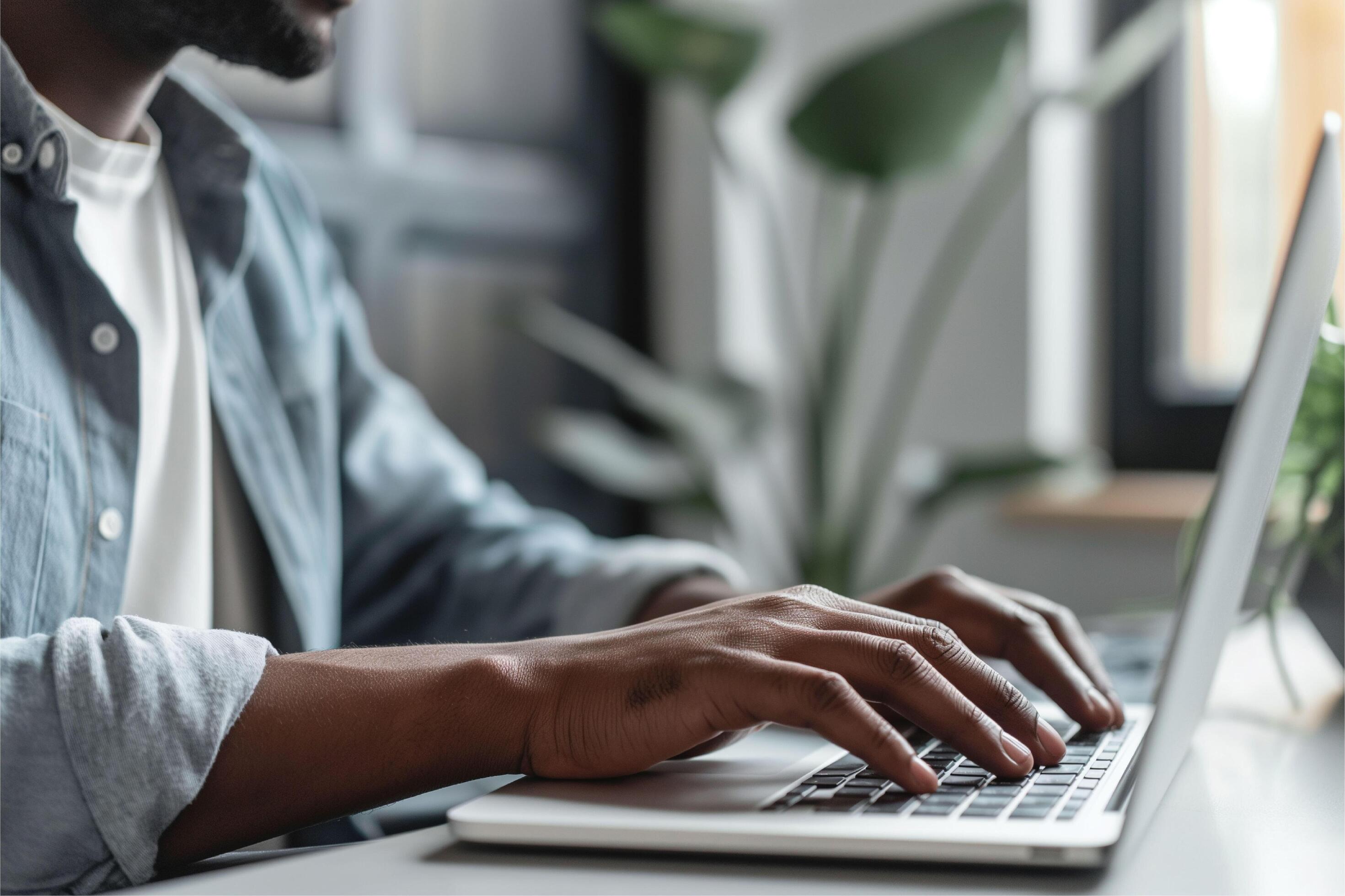 Portrait of happy arab freelancer man sitting at desk with laptop computer at home office Stock Free