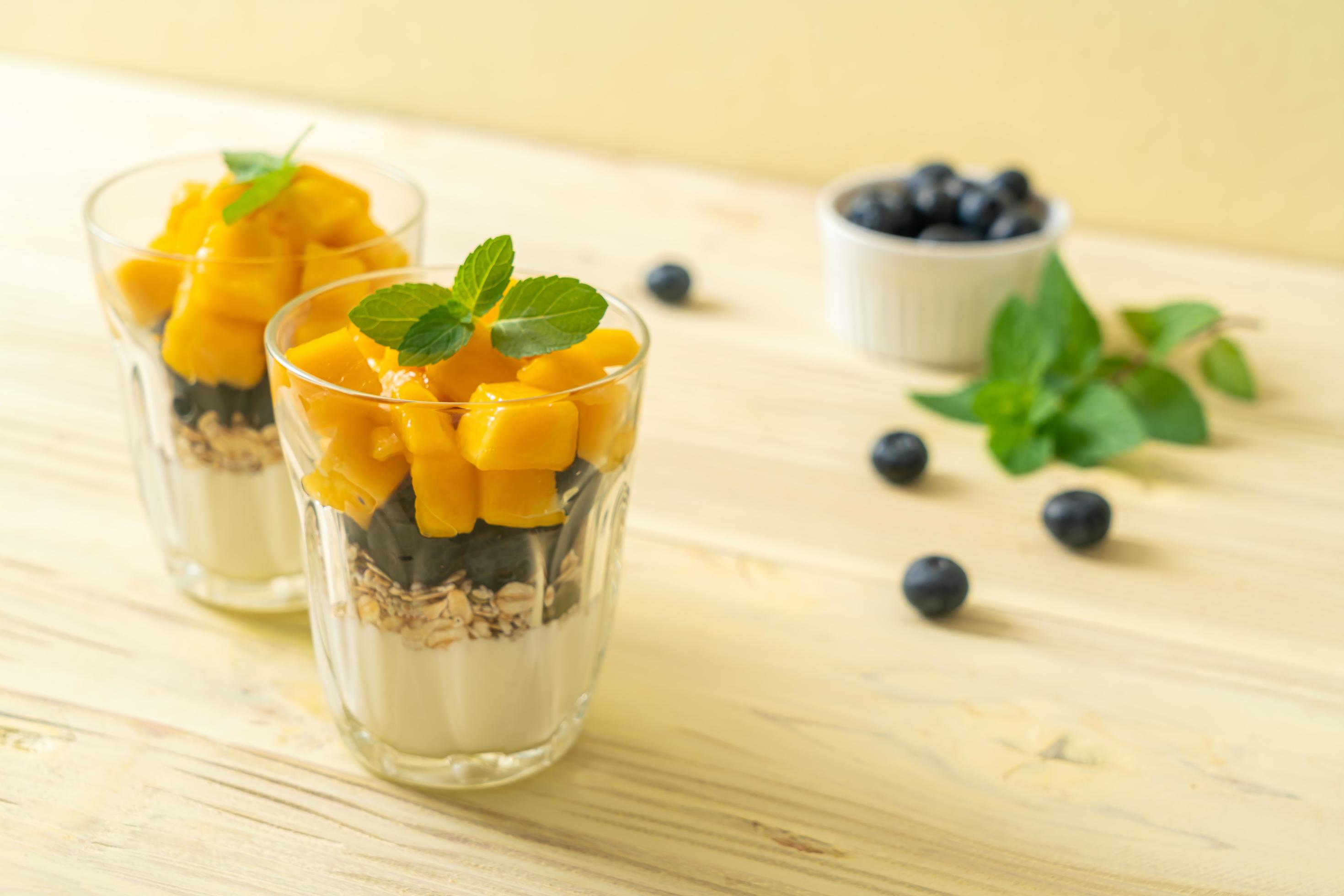 Homemade fresh mango and fresh blueberry with yogurt and granola – healthy food style Stock Free