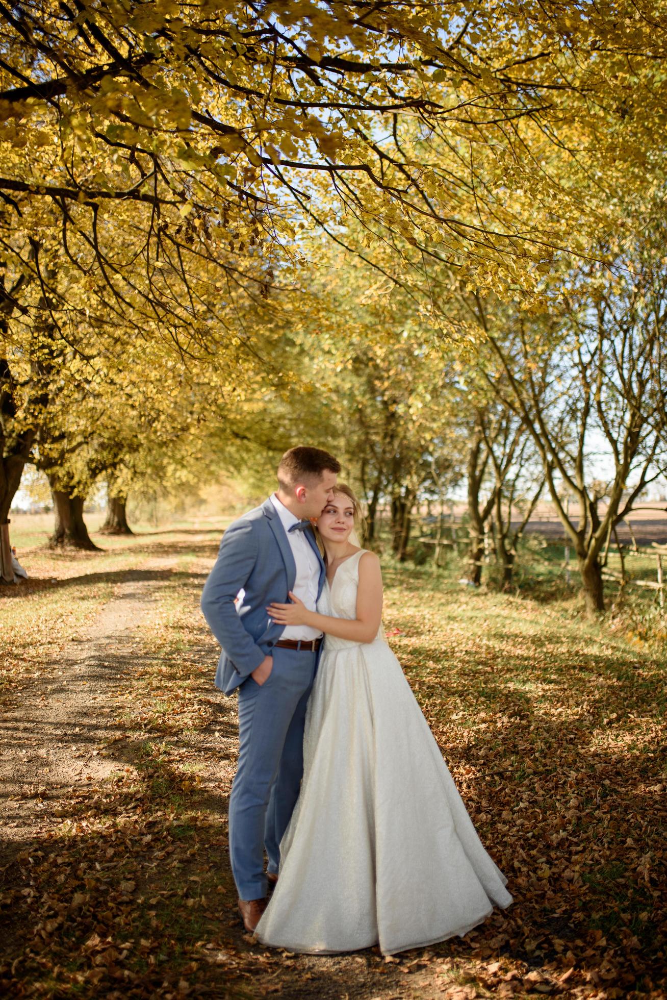 Young beautiful couple hugging in their wedding dresses in autumn park. Stock Free