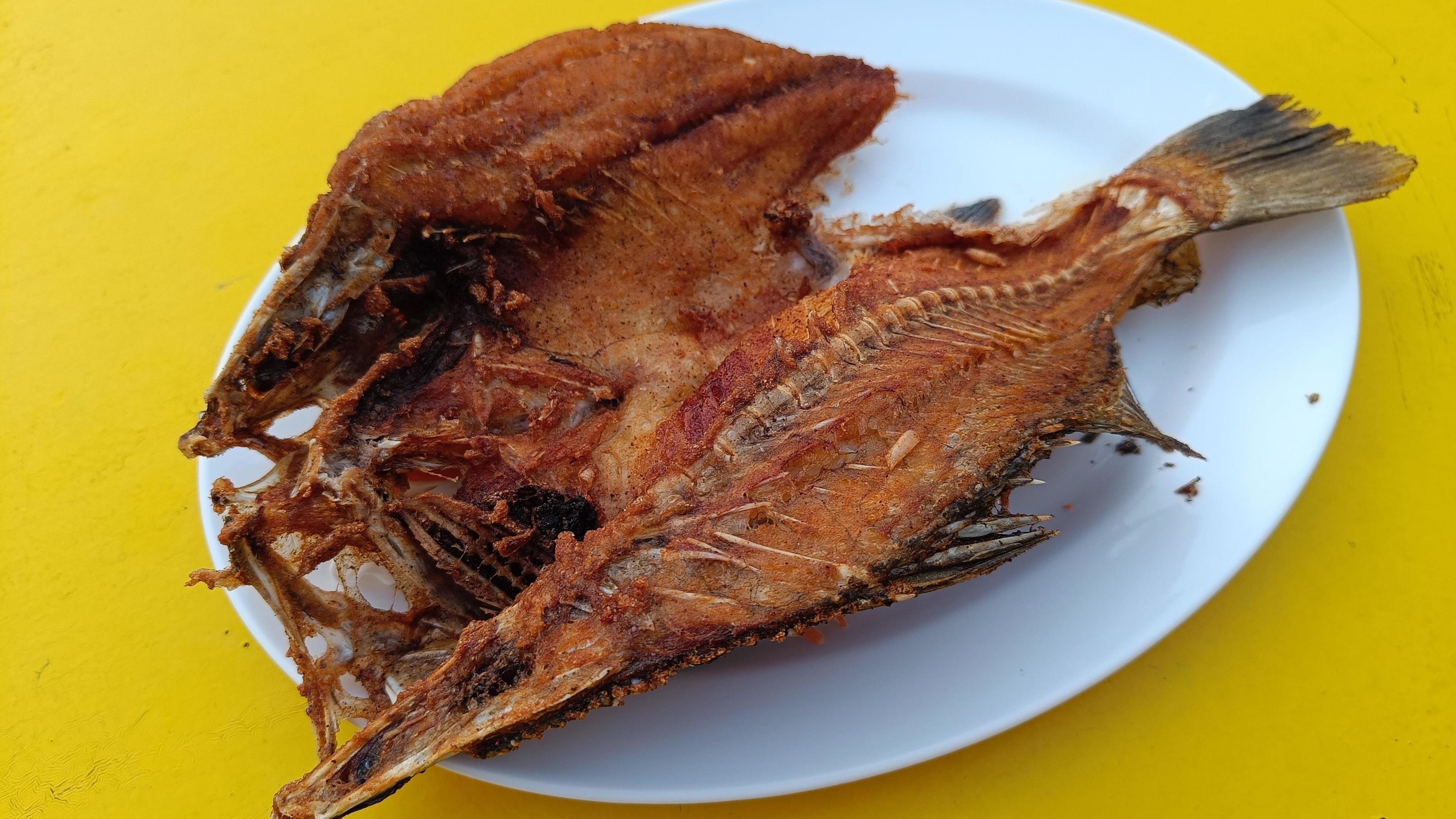 Delicious Asian fish fried served on a yellow table.Thai food Stock Free