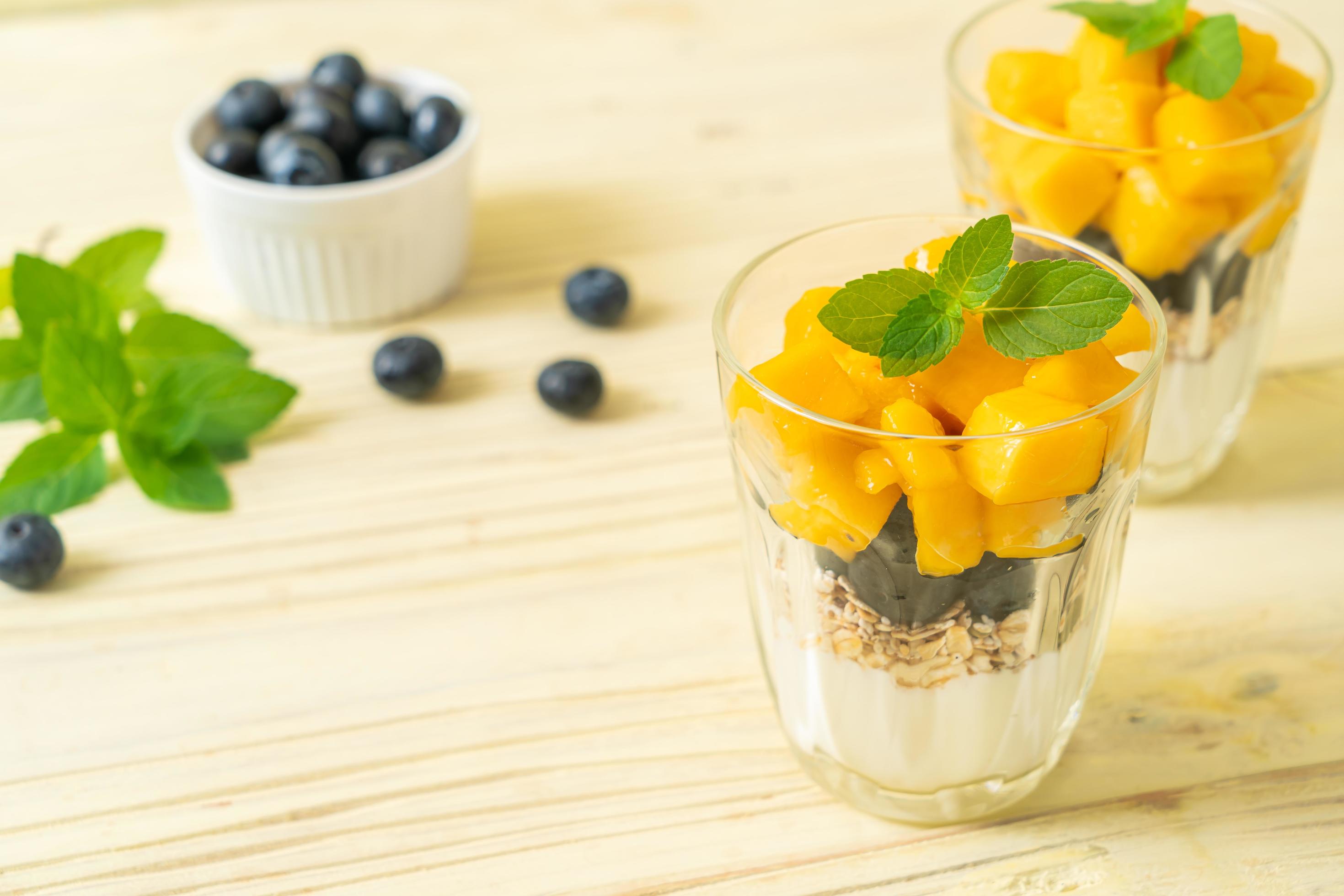 Homemade fresh mango and fresh blueberry with yogurt and granola – healthy food style Stock Free