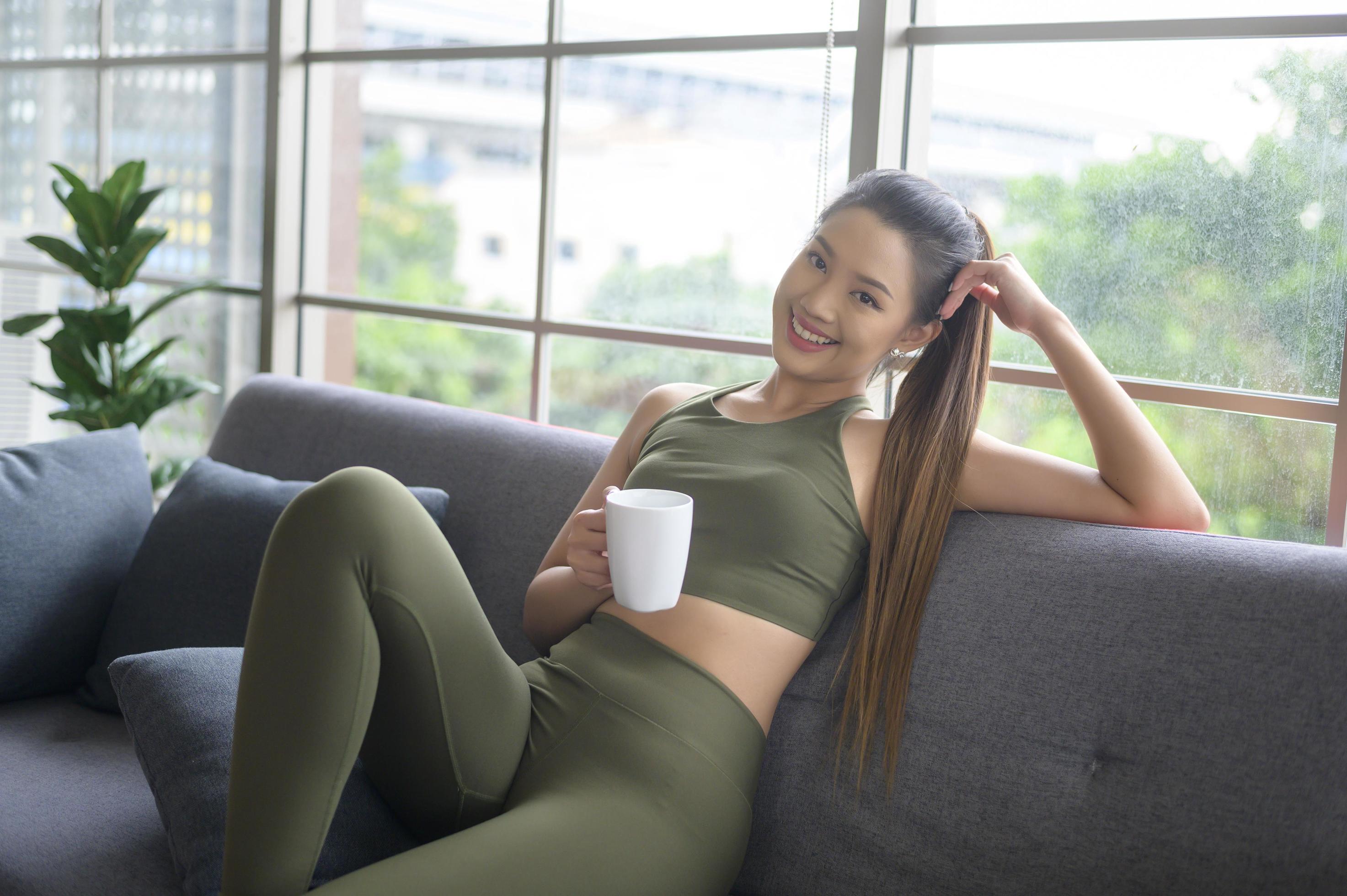 Young fitness woman in sportswear having a cup of coffee after exercising at home, Healthy and Lifestyles. Stock Free