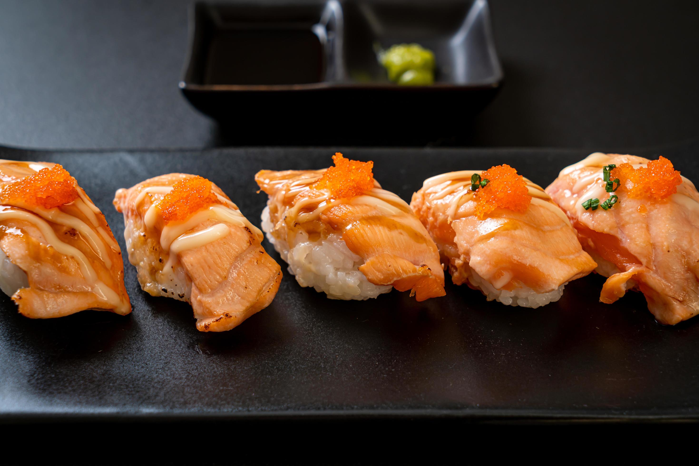 Grilled salmon sushi on black plate – Japanese food style Stock Free