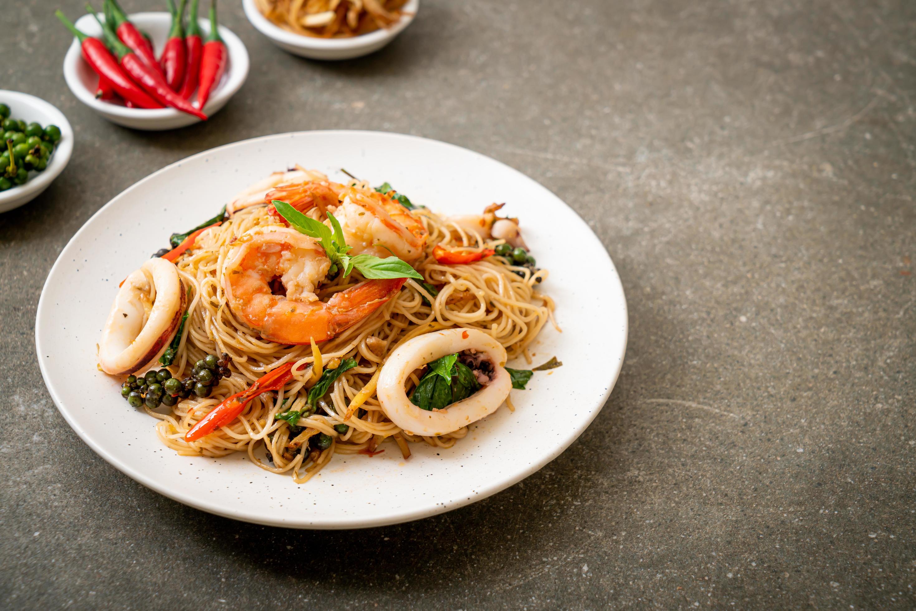 Stir-fried Chinese noodles with basil, chili, shrimp, and squid – Asian food style Stock Free