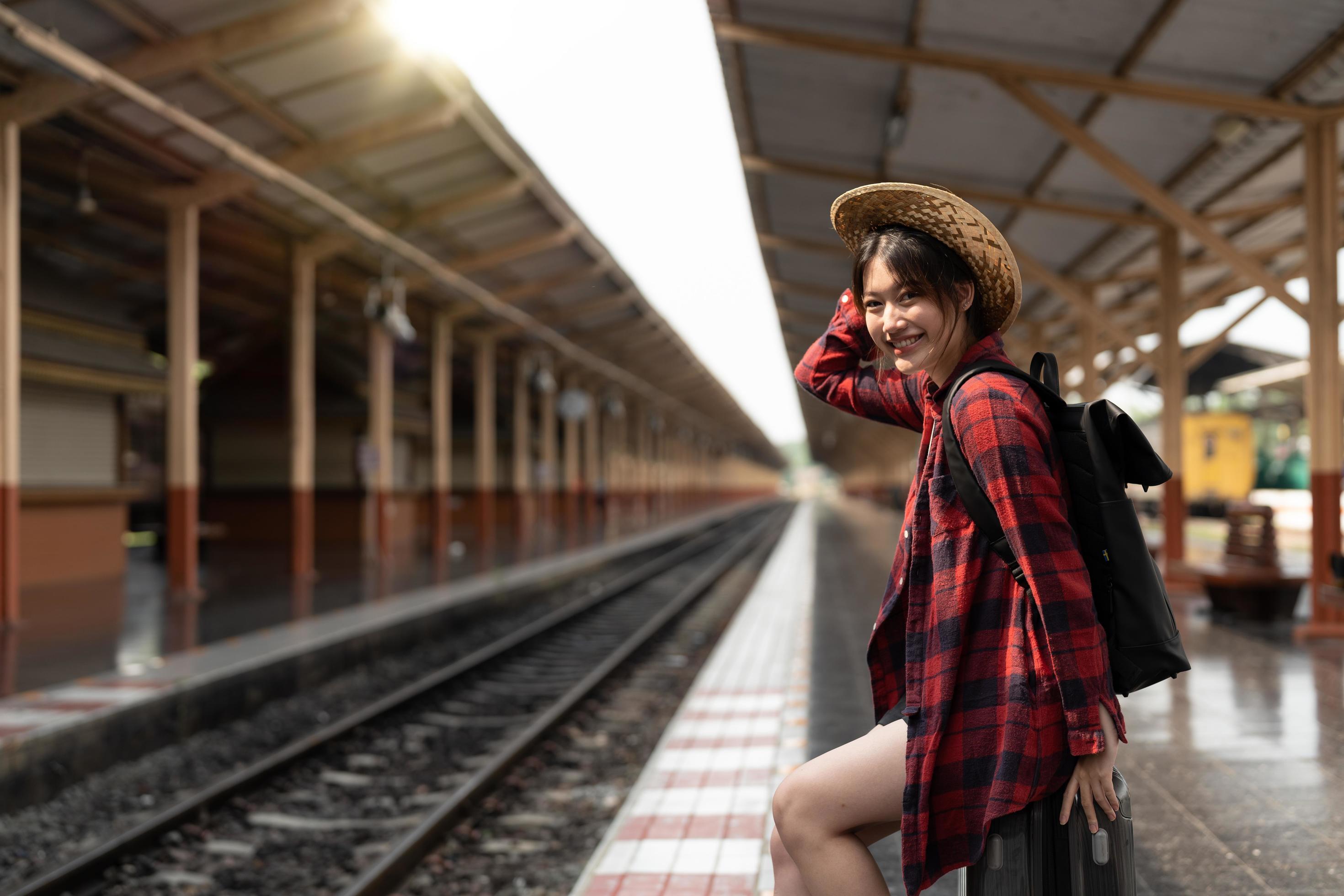 Happy asia woman traveller feeling happiness before go to travel at the train station, summer travel and lifestyle concept Stock Free