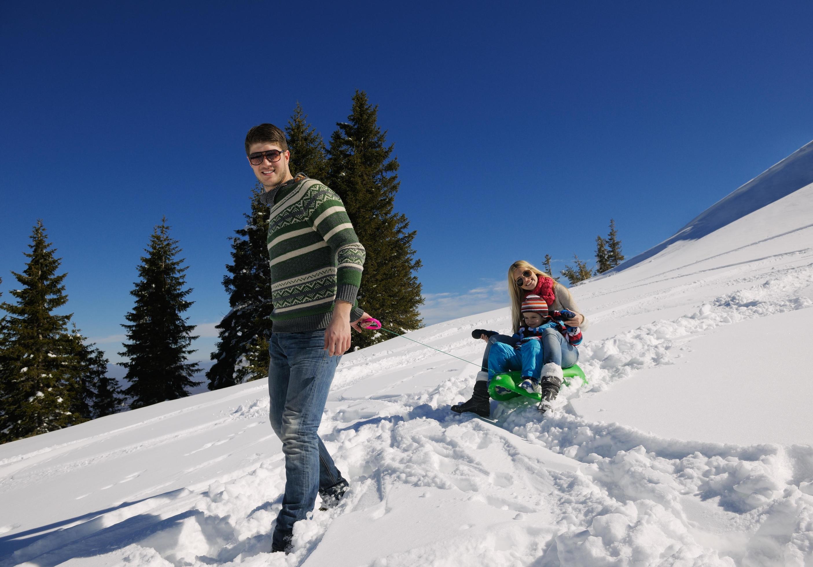 family having fun on fresh snow at winter vacation Stock Free