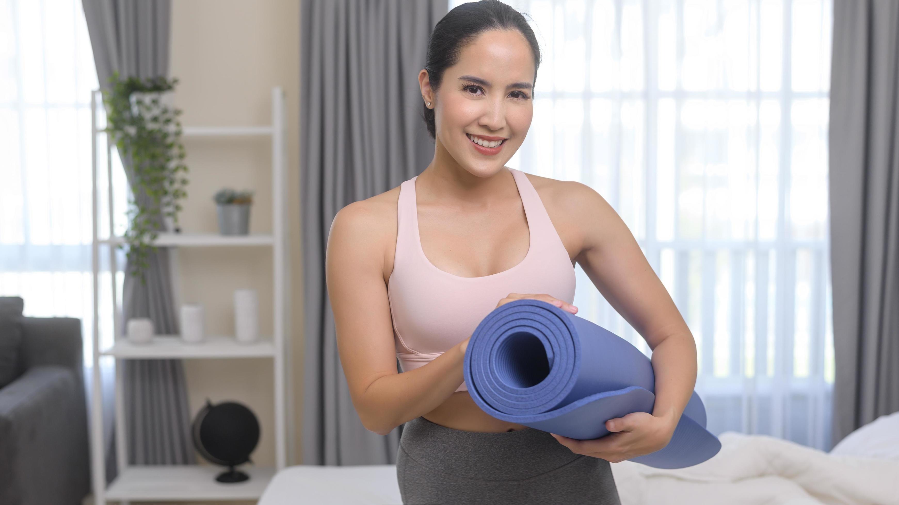 Fit young woman holding yoga mat, sport and healthy lifestyle concept. Stock Free