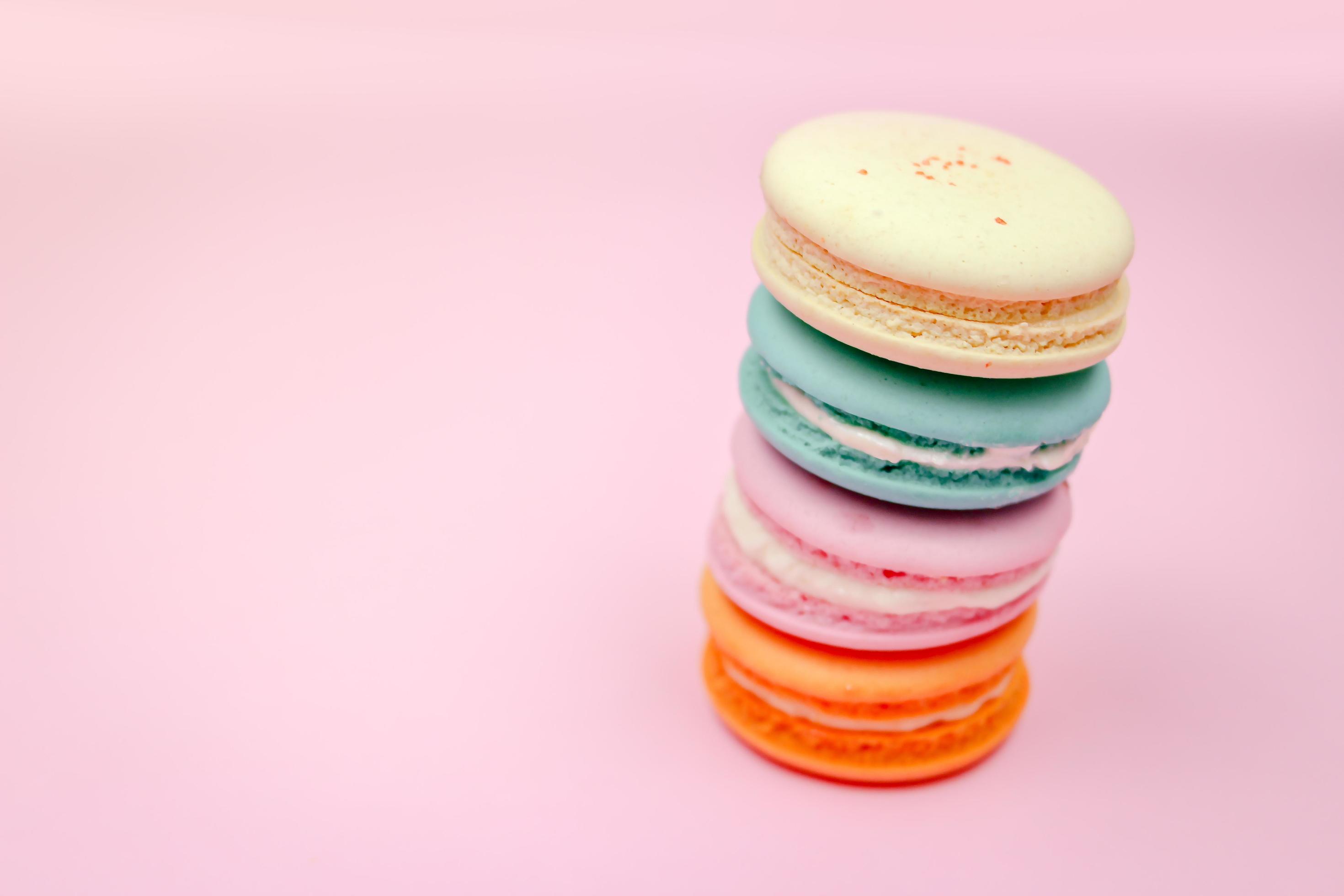 Colorful french macarons macaroons cake, delicious sweet dessert on a pink background with copyspace, food background concept. Stock Free