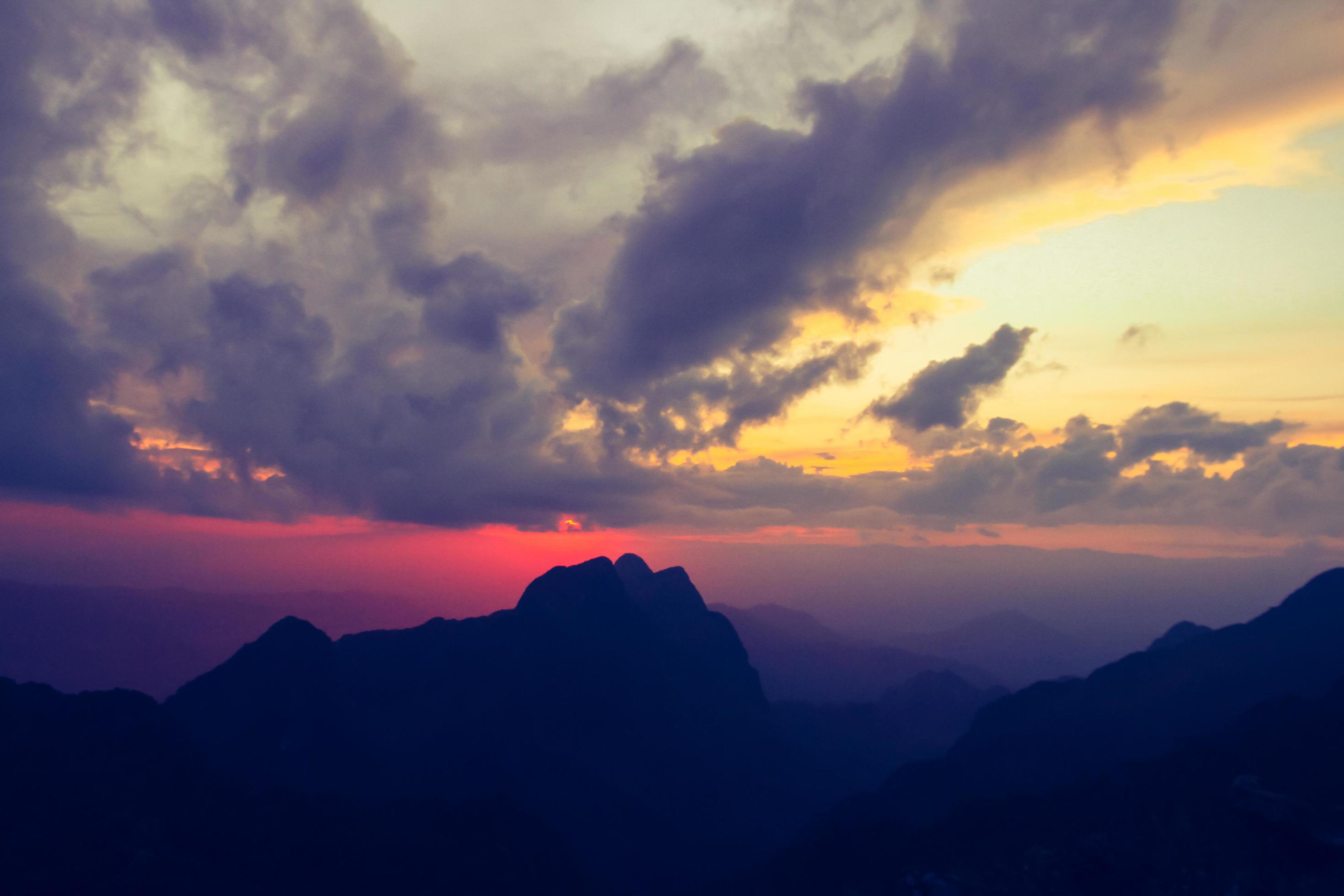 Sunset in sky and cloud, beautiful colorful twilight time with silhouette of mountain. Stock Free