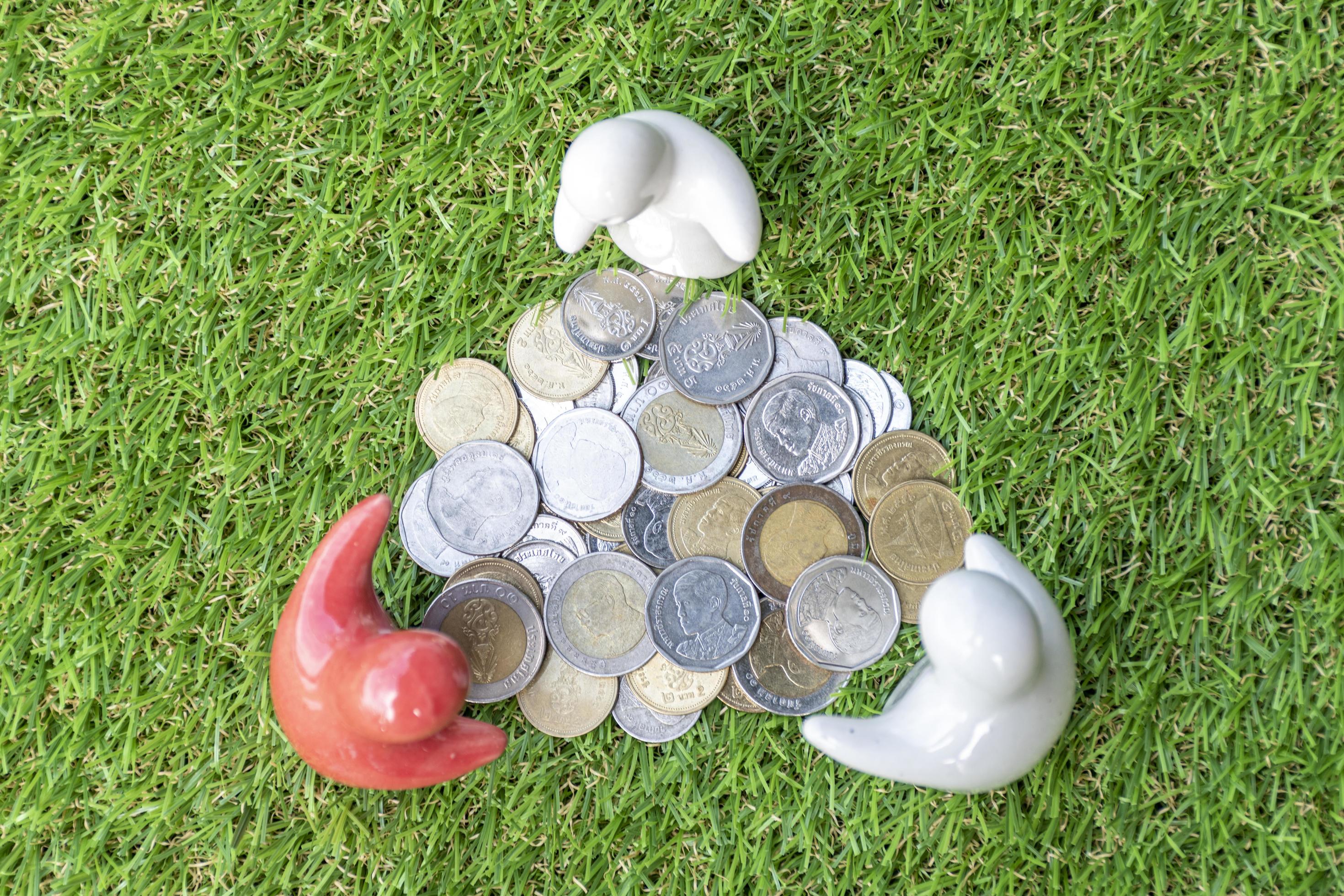 Top view mock up family statue and coins on grass floor with white background Stock Free