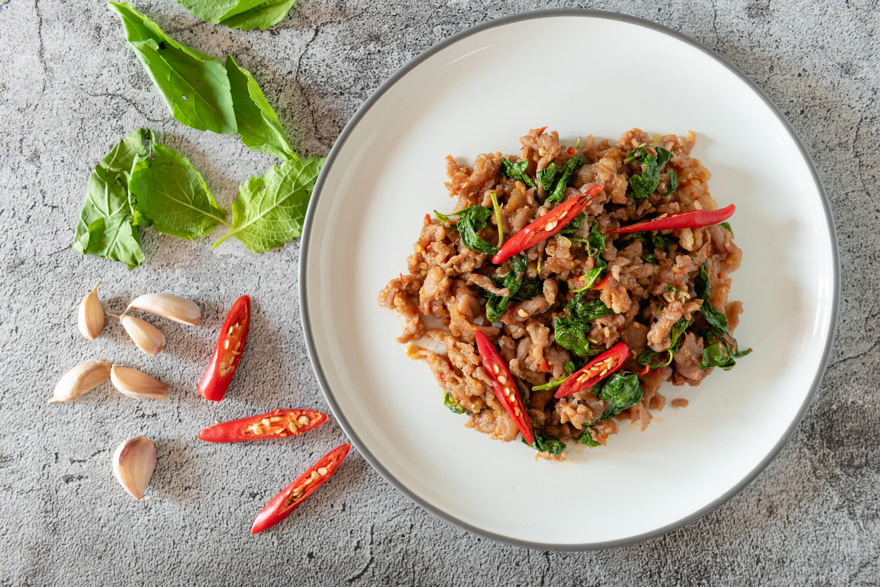 Stir fried minced pork with basil on background as Thai street food for local recipe Stock Free