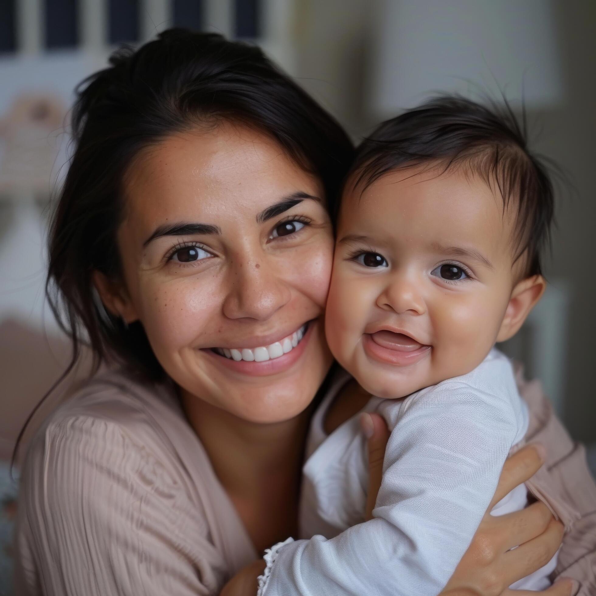 Portrait of a smiling woman holding a baby suitable for family or childcare industry Stock Free