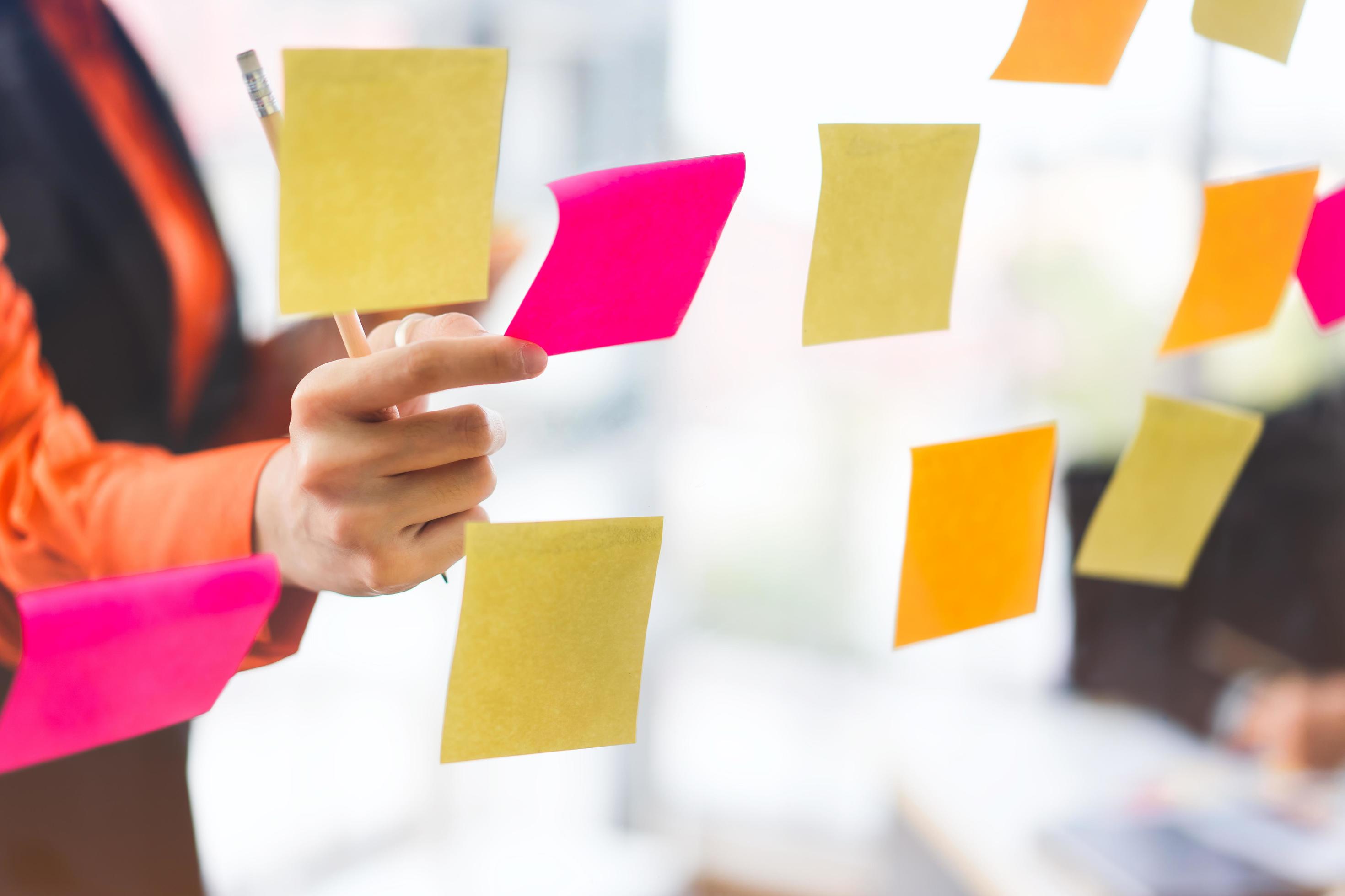 Business woman hand use post it on glass for stick information Stock Free