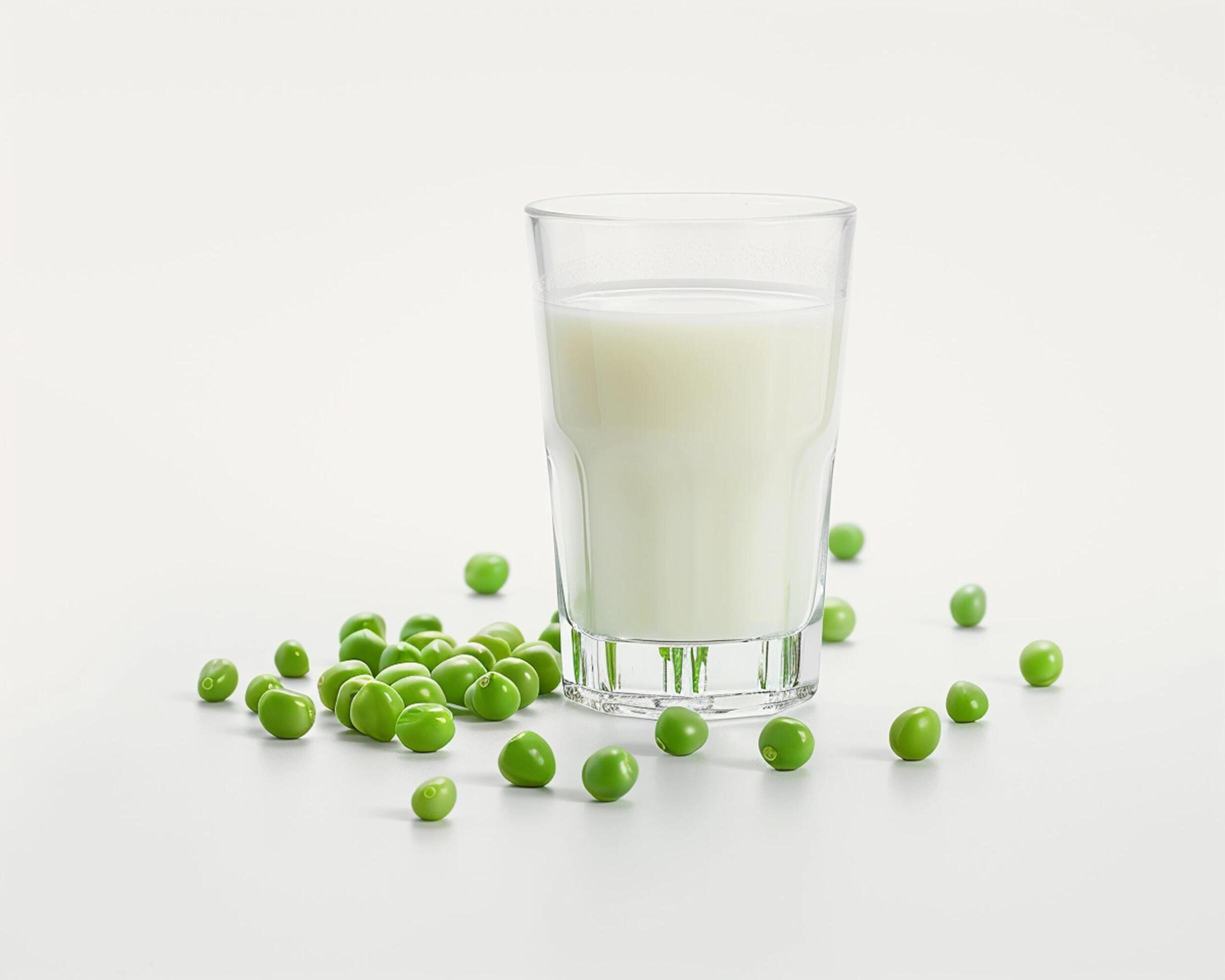 a glass of milk and peas on a white background Stock Free