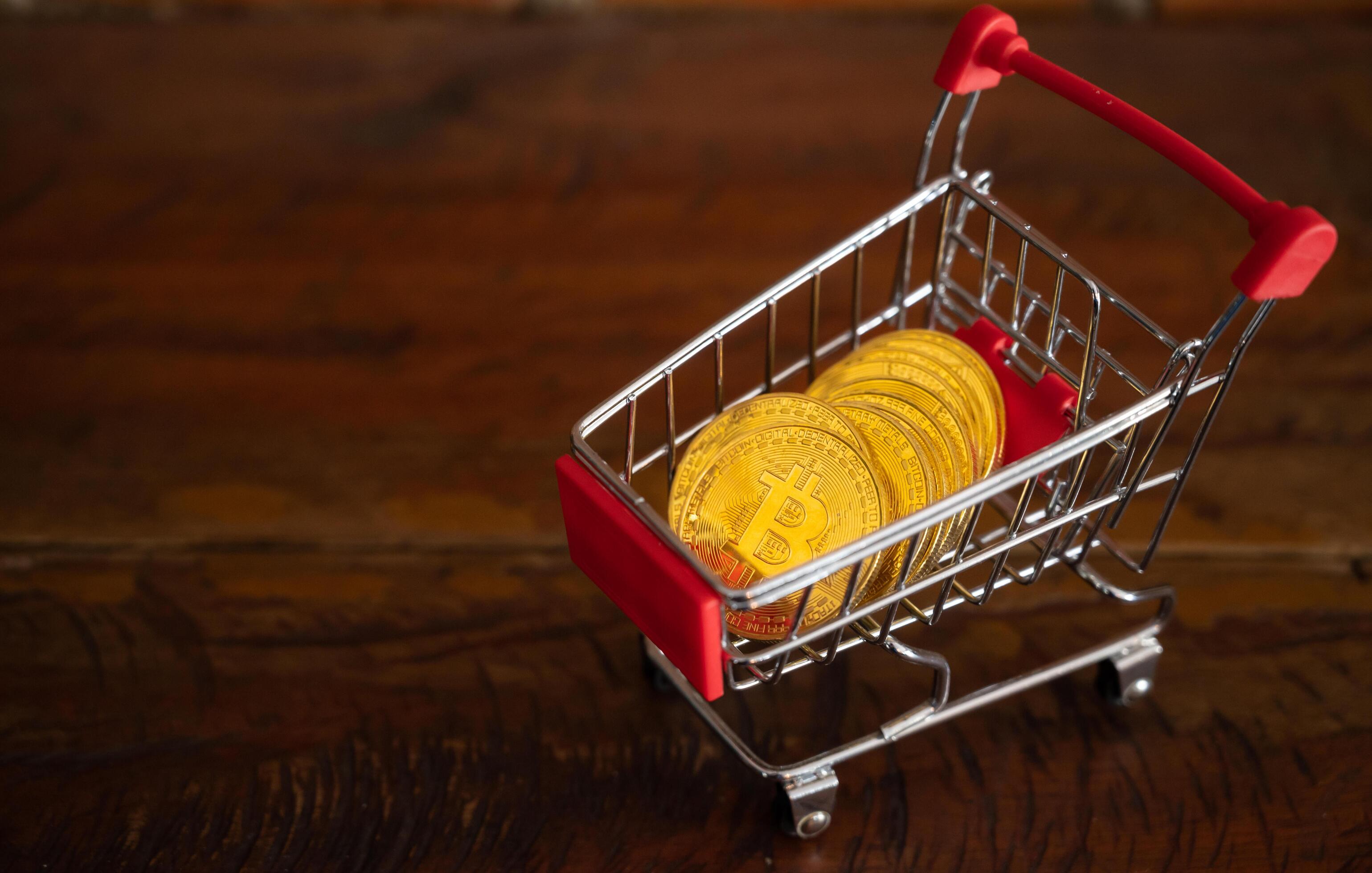 Bitcoin token in a trolley on wooden table. Bitcoin is one of the popular cryptocurrency, a virtual currency or a digital currency. Stock Free