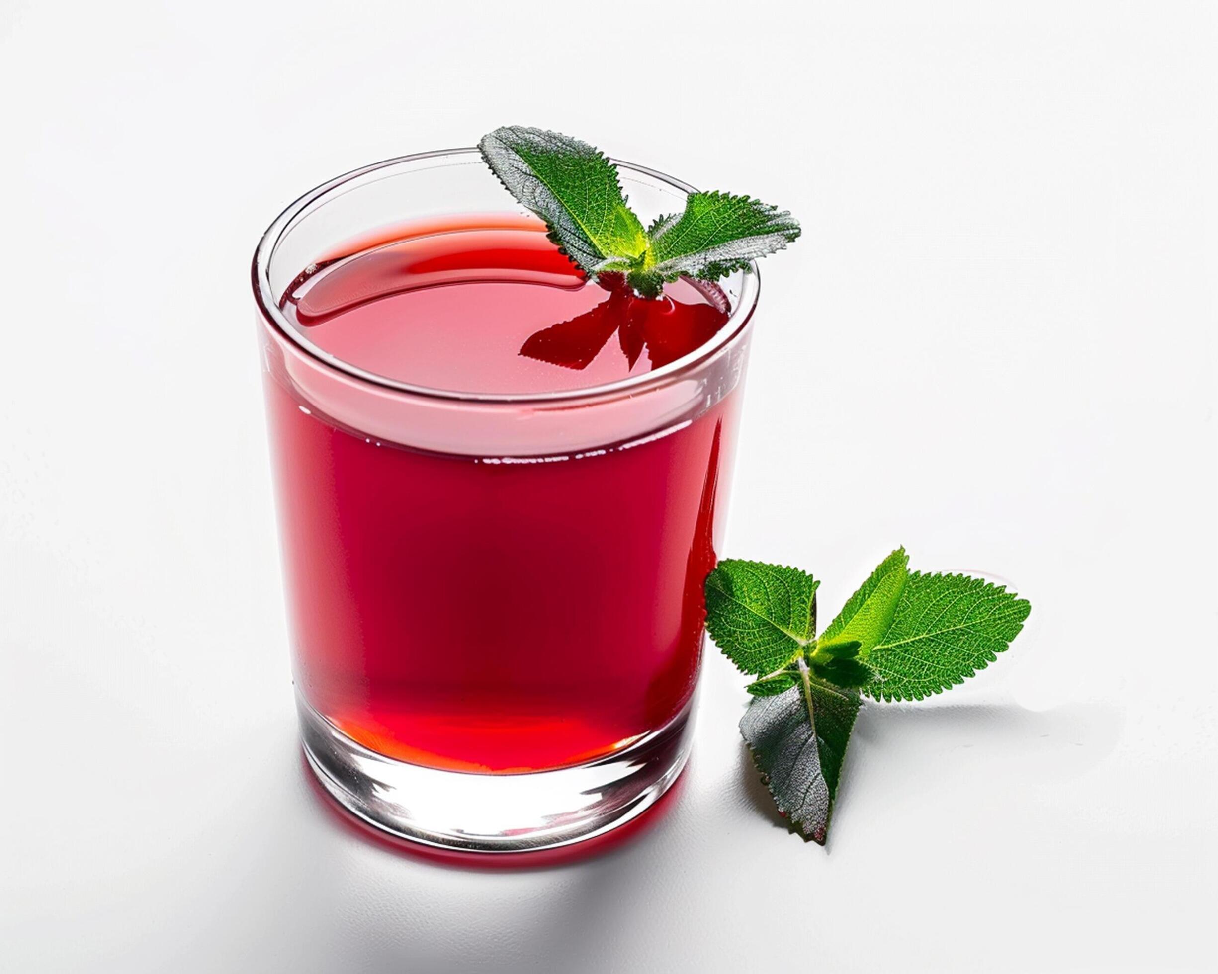 
									a glass of red juice with a leaf on top Stock Free