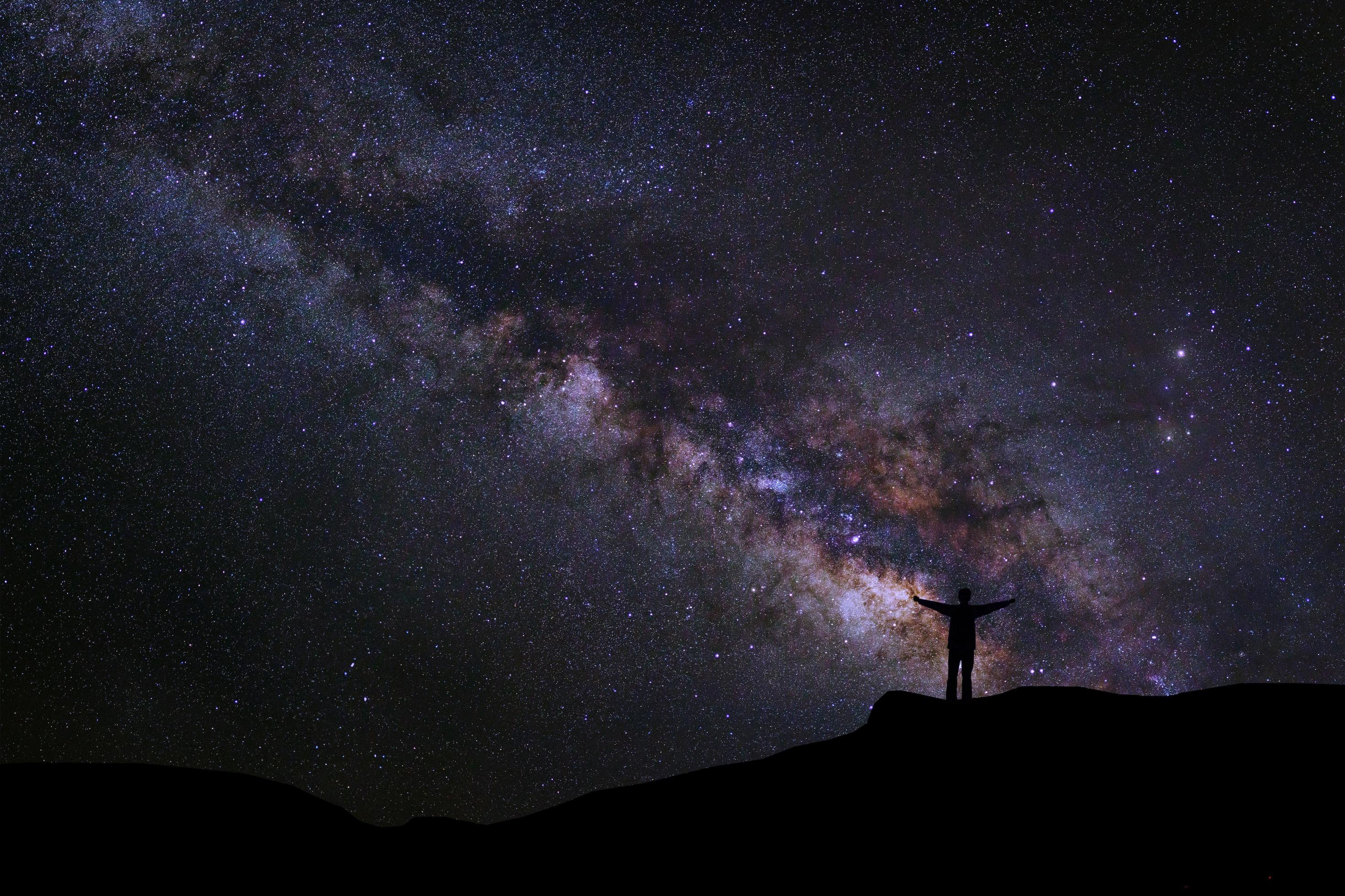 Landscape with milky way, Night sky with stars and silhouette of happy people standing on the mountain, Long exposure photograph, with grain Stock Free