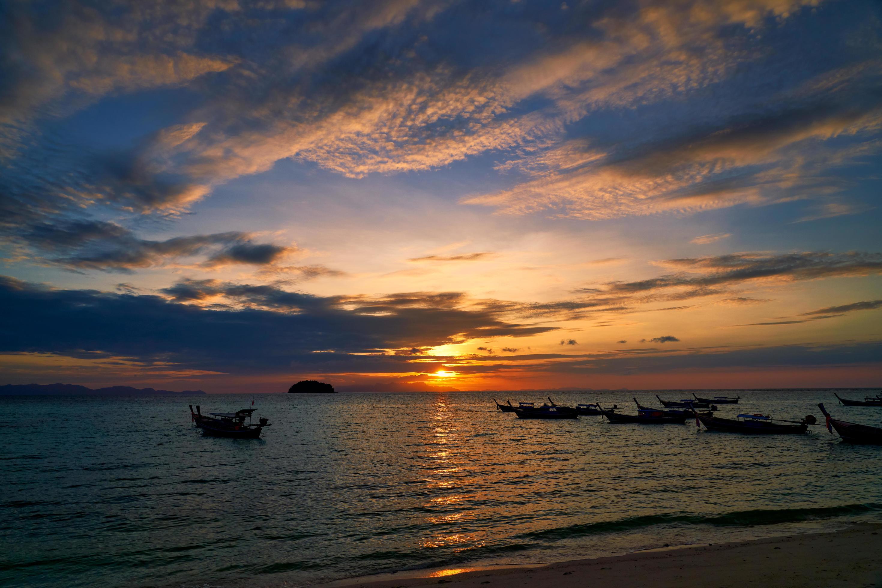 Silhouetted boats with colorful cloudy sunrise Stock Free