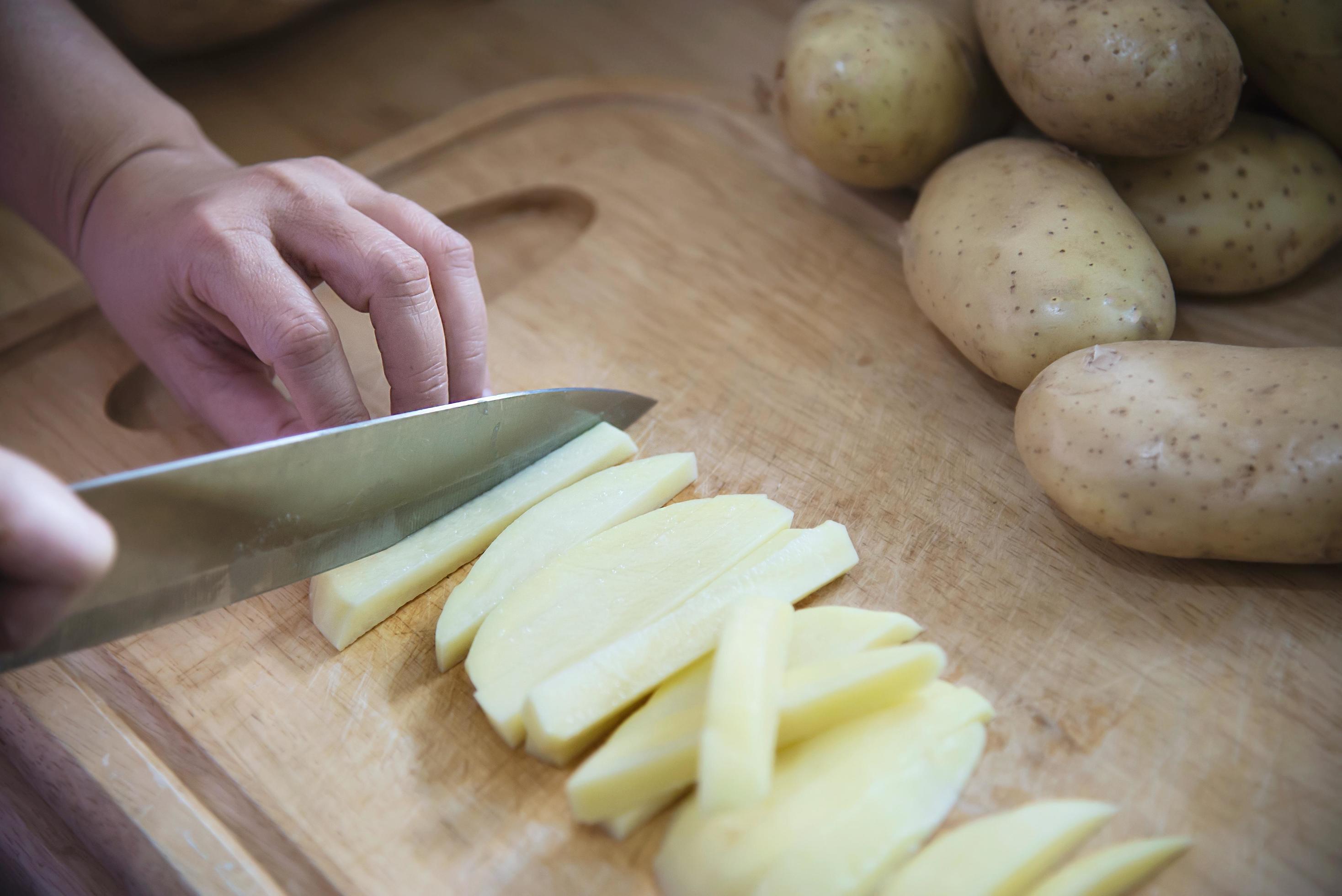 People cooking fresh potato preparing food in the kitchen – potato cooking concept Stock Free