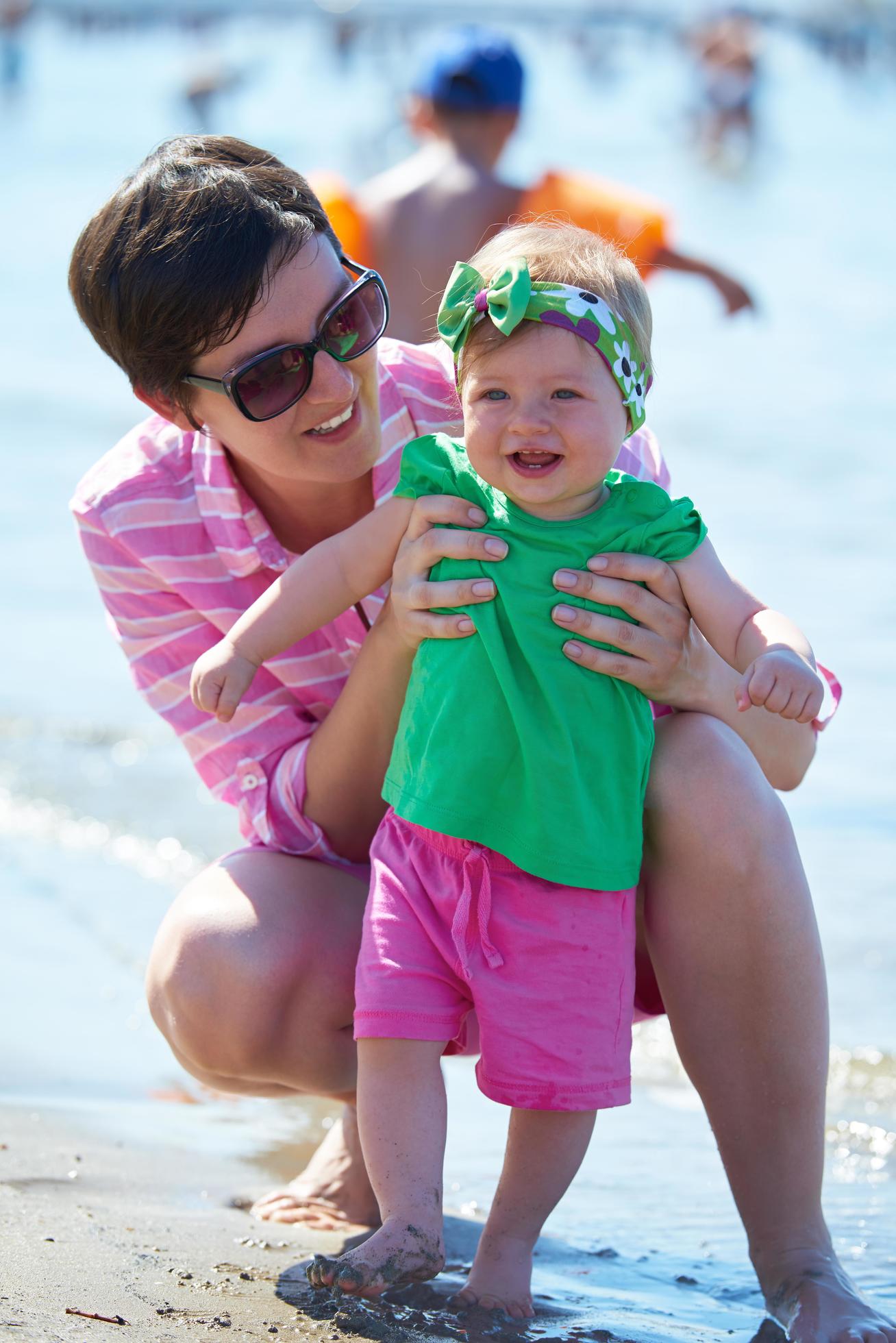 mom and baby on beach have fun Stock Free