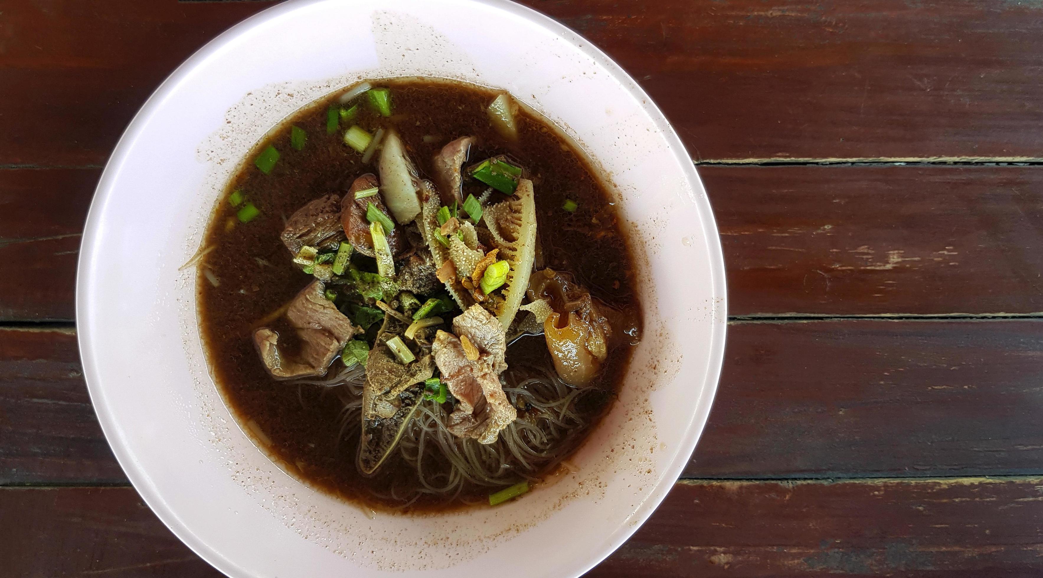 Top view of Thai noodle with, pork or beef liver and blood soup on pink bowl. Flat lay of Asian and famous food in Thailand. Stock Free