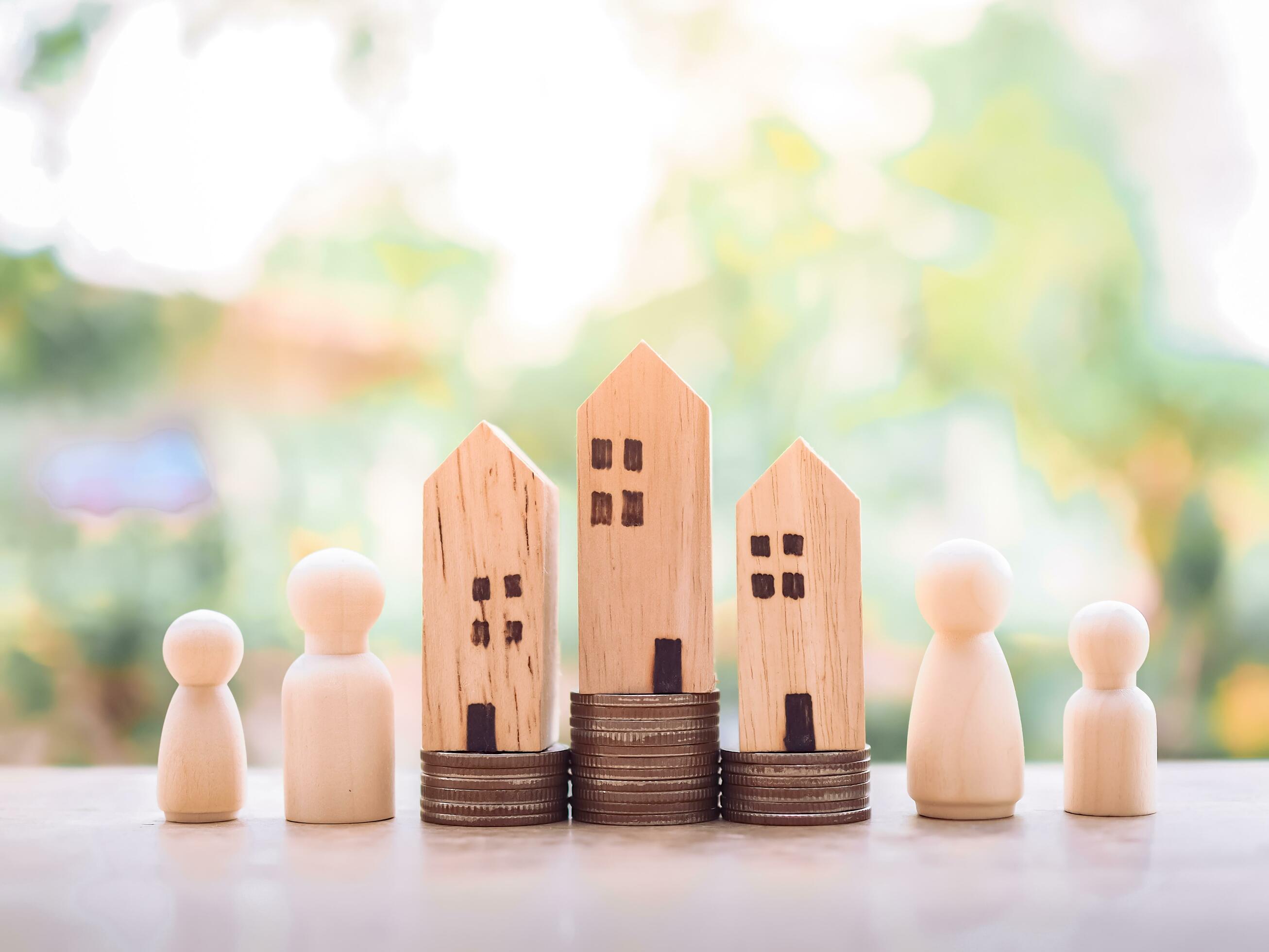 Miniature house on stack of coins with wooden figure of the family for Investment property concept. Saving money for buy a house. Stock Free