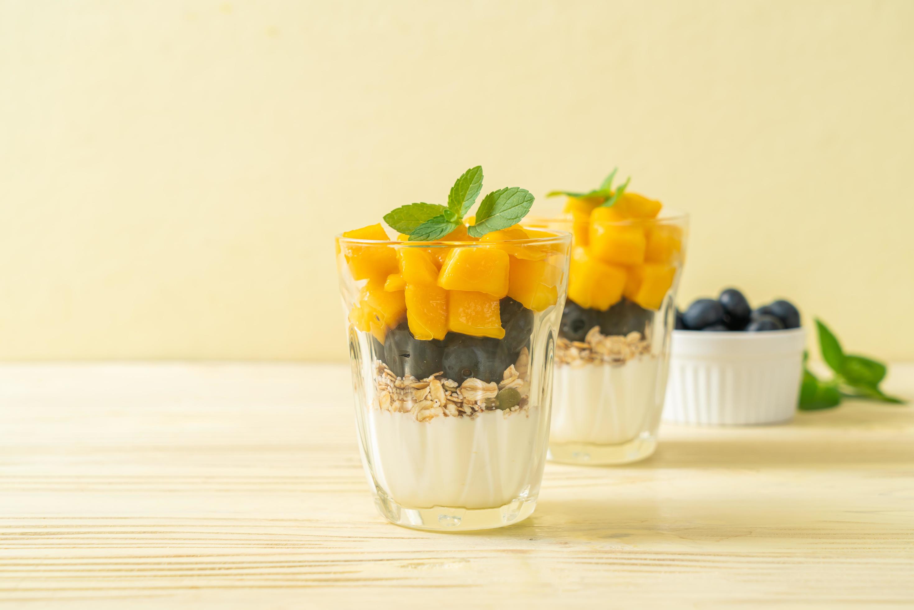 Homemade fresh mango and fresh blueberry with yogurt and granola – healthy food style Stock Free