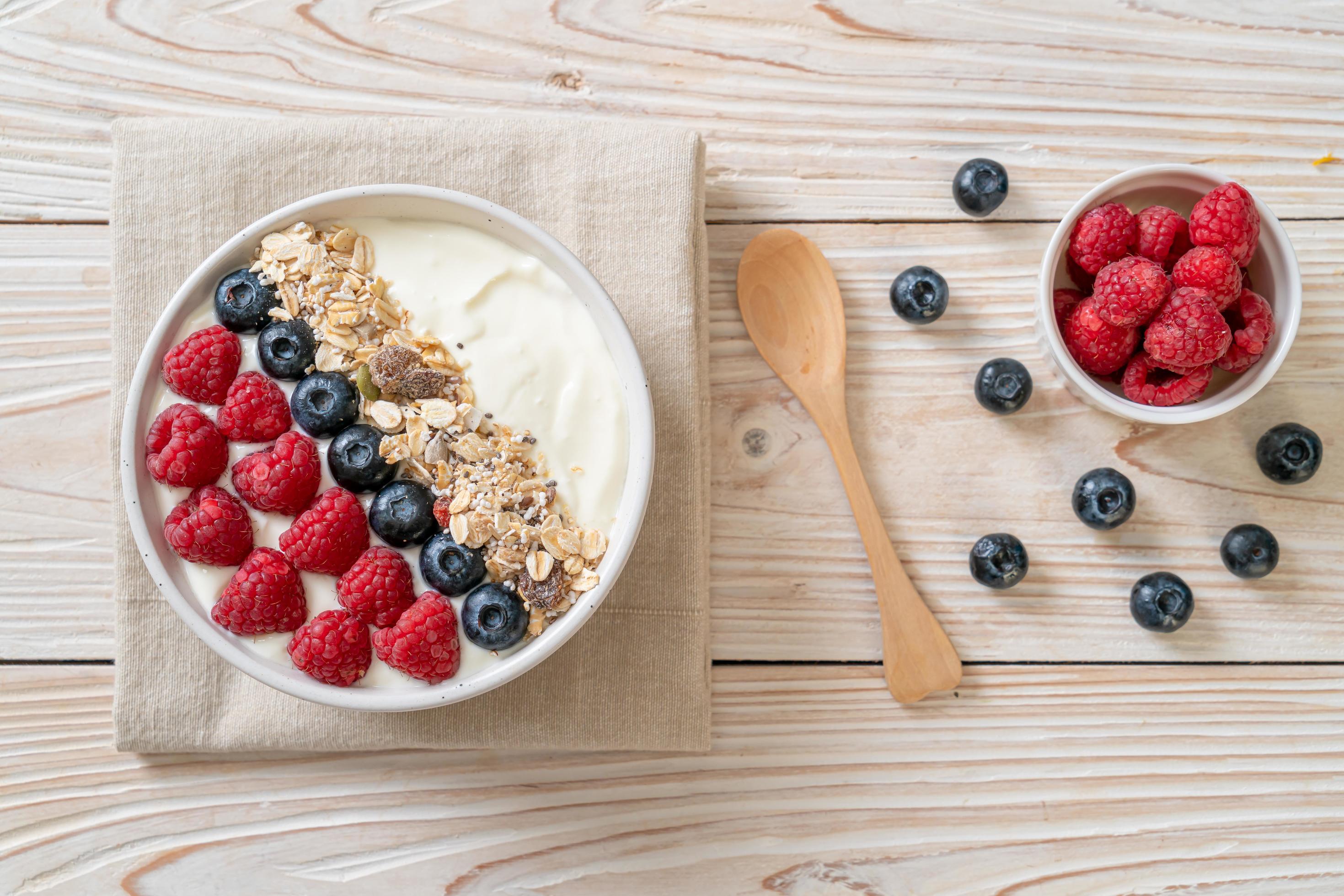 Homemade yogurt bowl with raspberry, blueberry and granola – healthy food style Stock Free