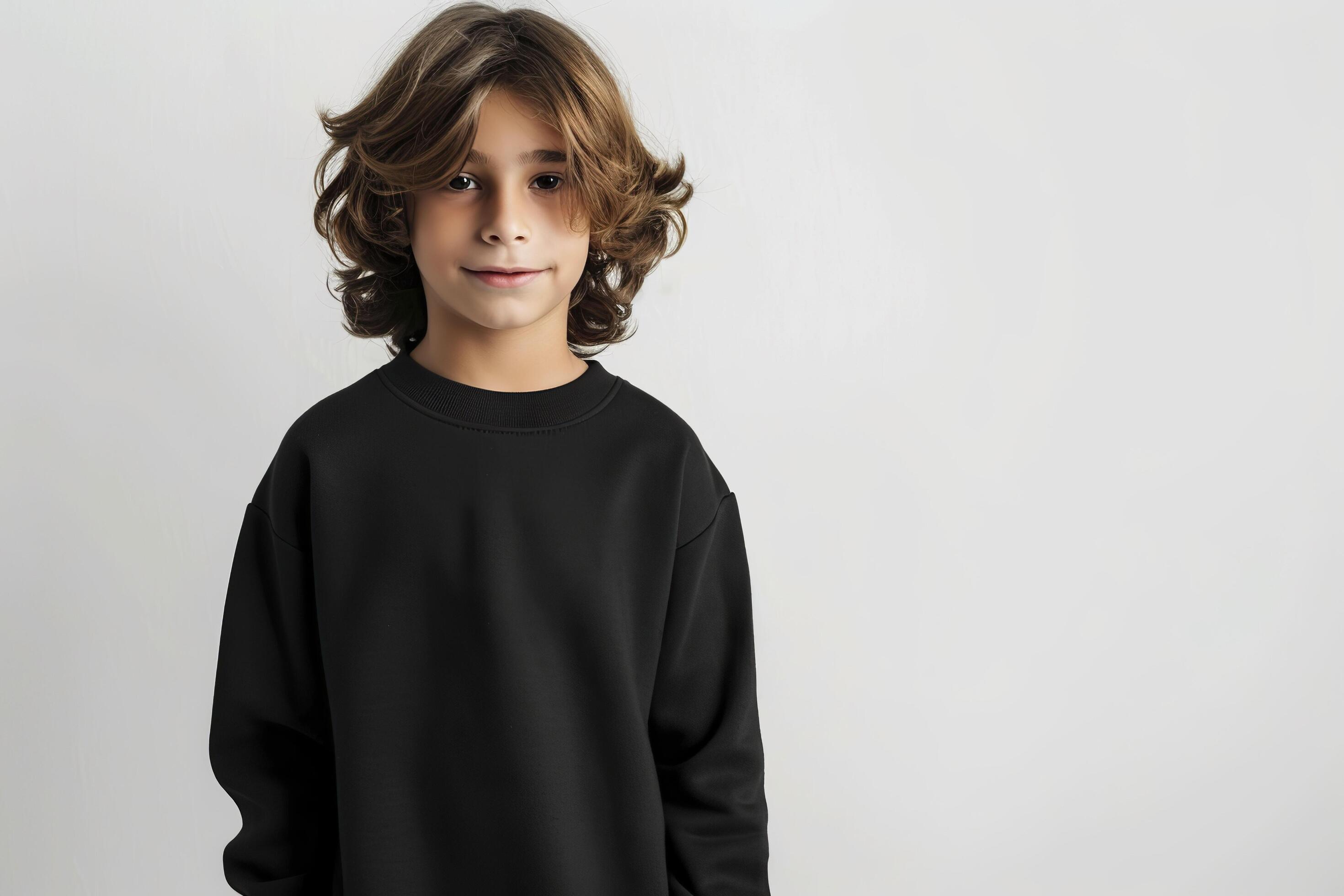 Cute boy in a black sweatshirt on a gray background. Kids sweatshirt mockup. Stock Free