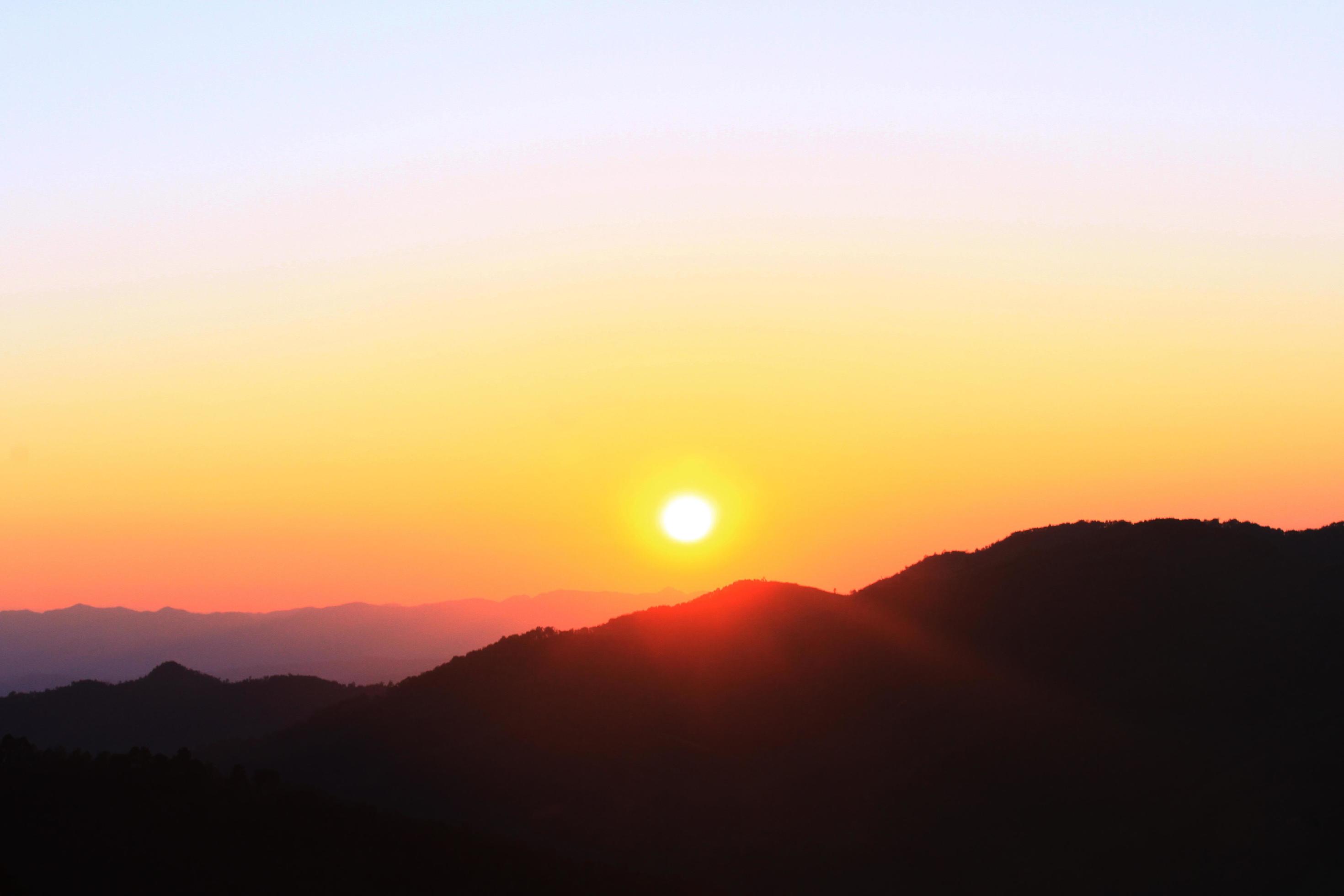 Sunset in sky and cloud, beautiful colorful twilight time with silhouette of mountain. Stock Free